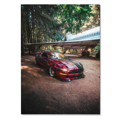 Red Ford Mustang S550 with black racing stripes parked in forest setting poster wall art.