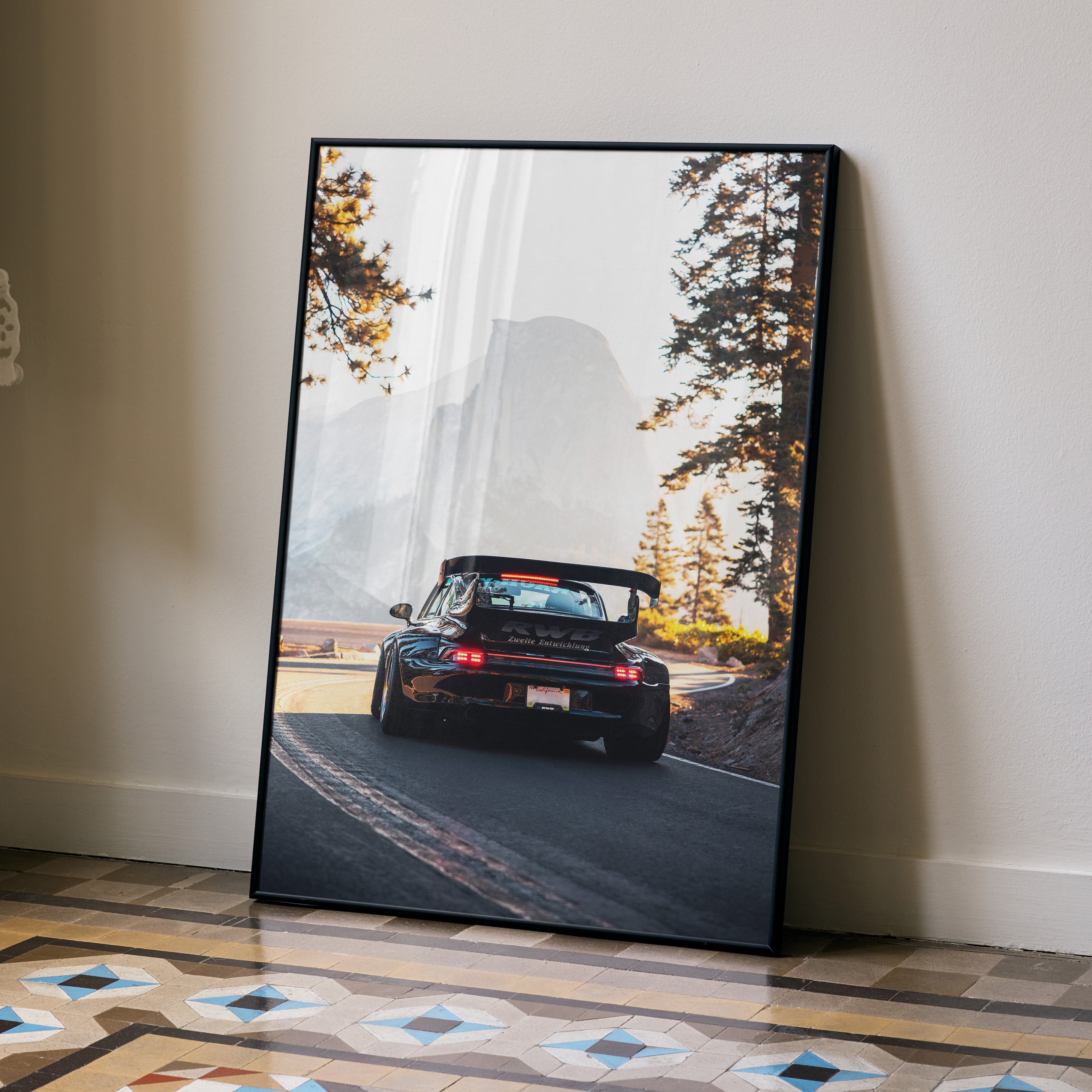 RWB Porsche 911 driving on scenic mountain road poster wall art in black frame.