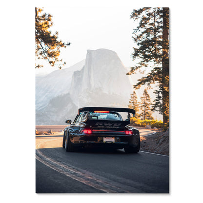 Poster wall art featuring a black RWB Porsche 911 driving on a mountain road at sunrise.