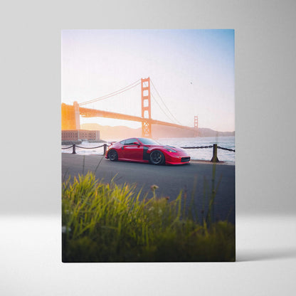 Vertical canvas art of a red Nissan 370z parked by the Golden Gate Bridge at sunset, museum quality wall art.