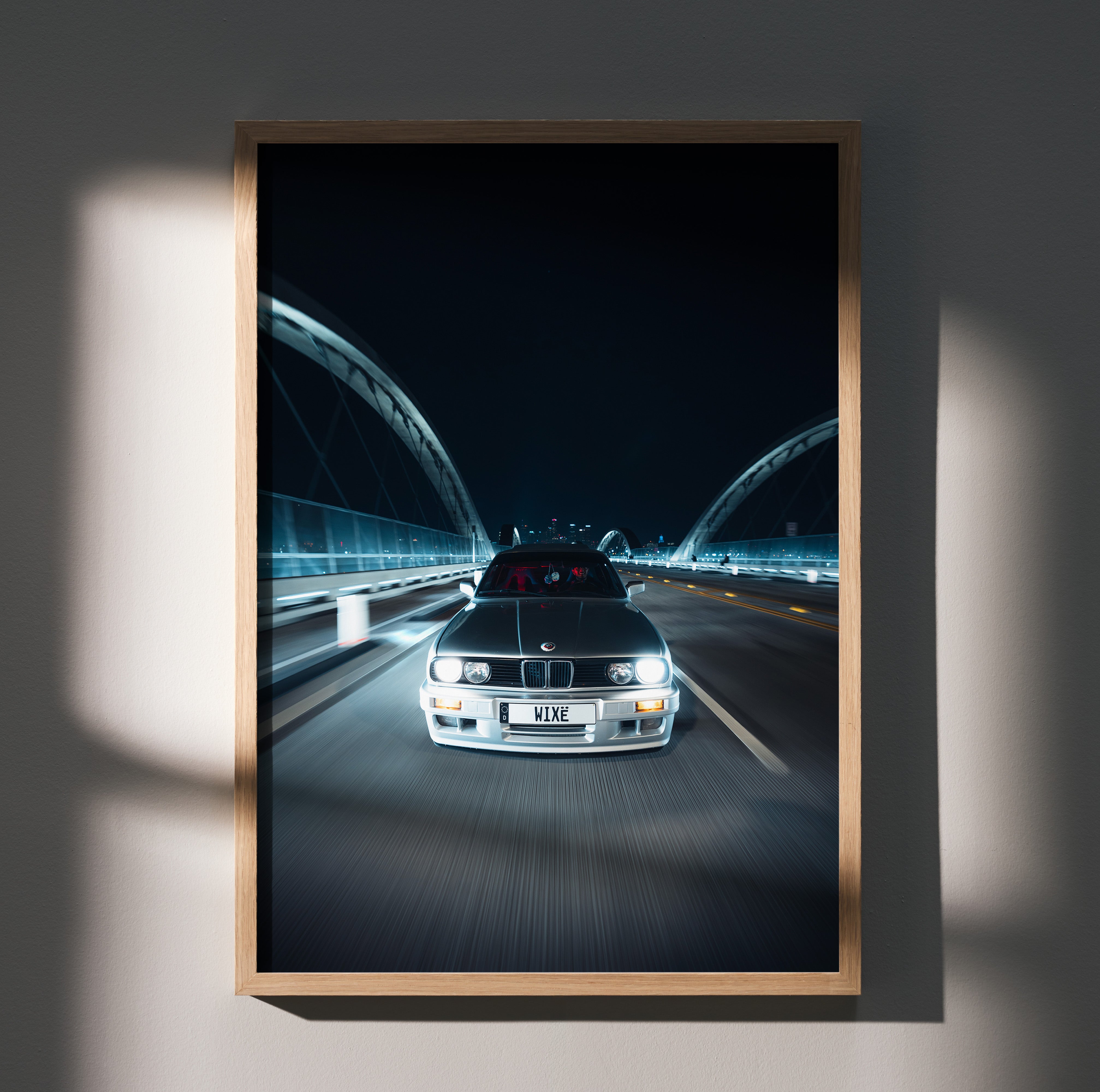 BMW E30 car driving on illuminated bridge at night poster wall art in wooden frame.