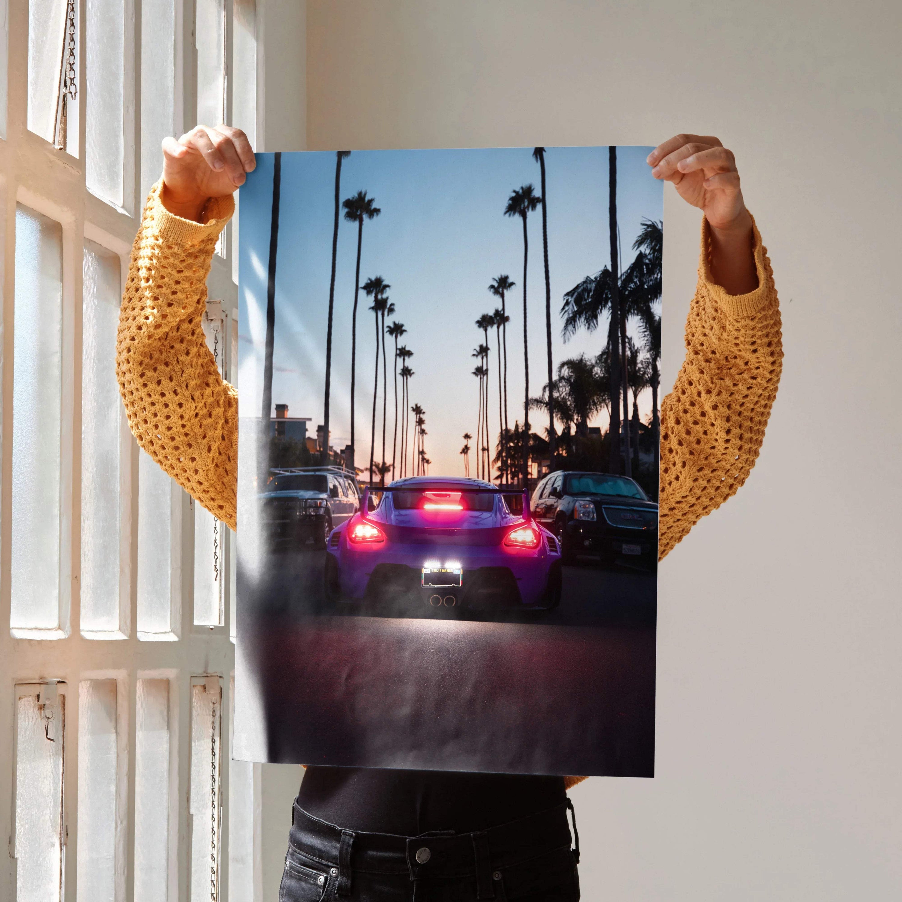 Porsche Cayman car poster showing rear view with palm trees at sunset, perfect wall art.