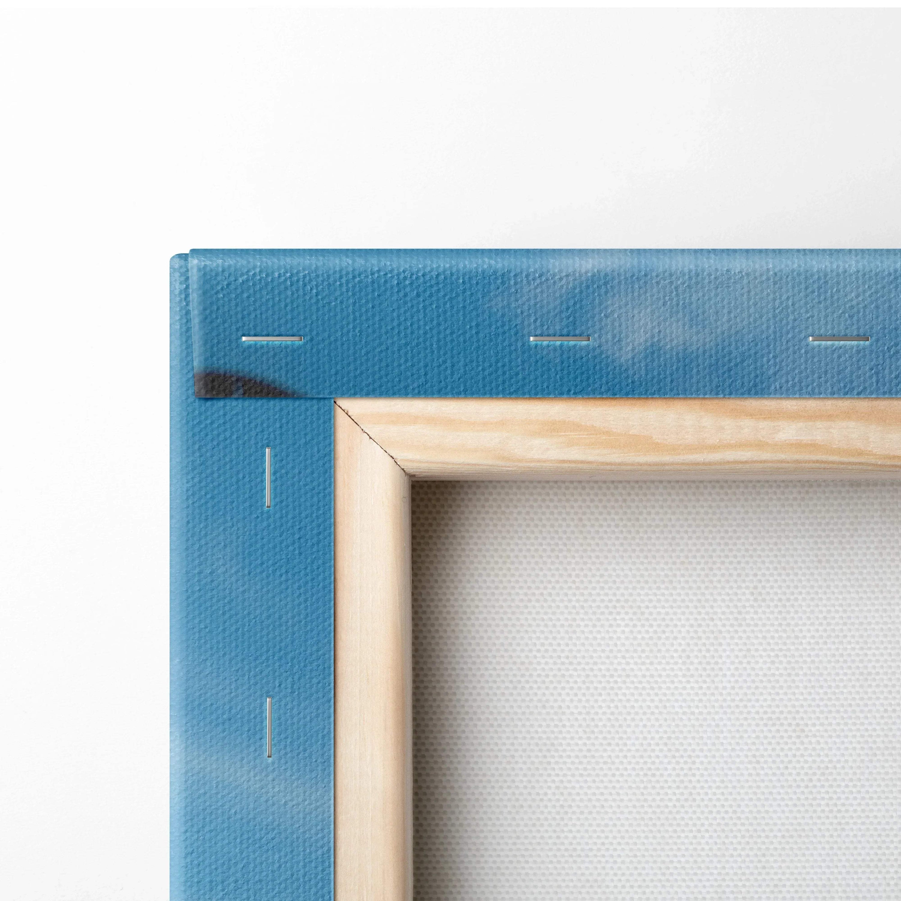 Close-up of wooden frame corner with blue fabric canvas wrapped for wall art display.