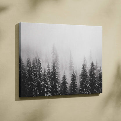 Winter forest scene on canvas wall art with snow-covered tree tops in grayscale decor.