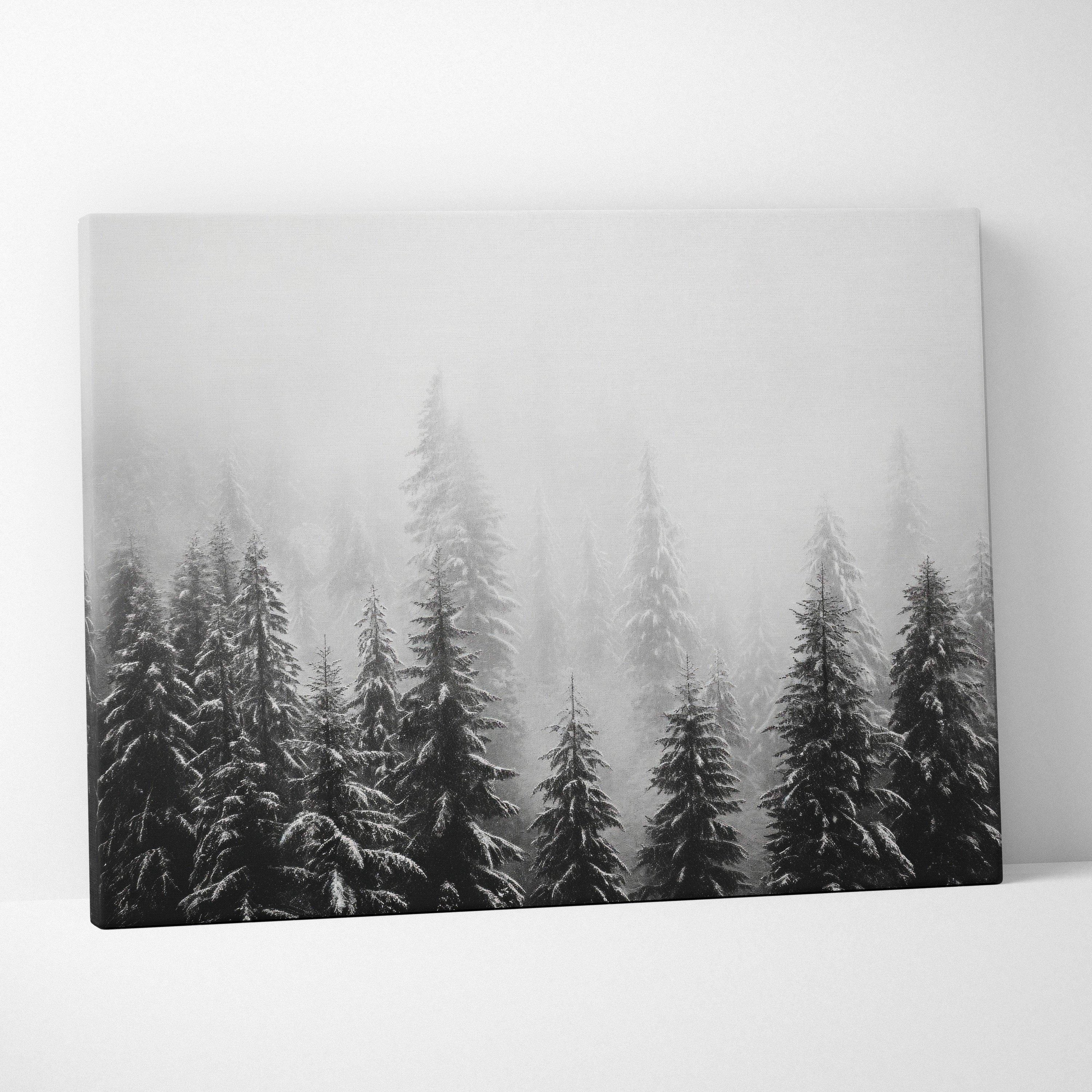 Canvas wall art featuring black and white digital print of snow-covered pine tree tops in misty winter forest.