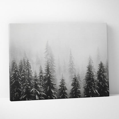 Canvas wall art featuring black and white digital print of snow-covered pine tree tops in misty winter forest.