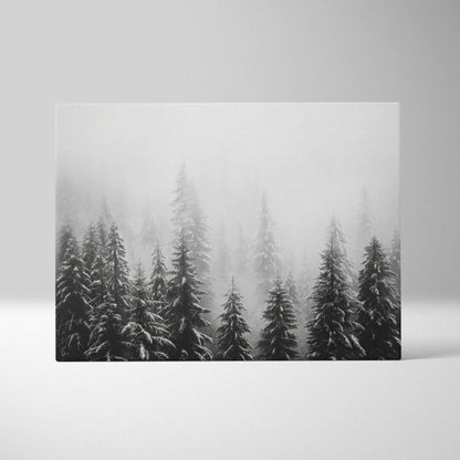 Black and white canvas wall art depicting snow-covered evergreen tree tops in misty forest decor.