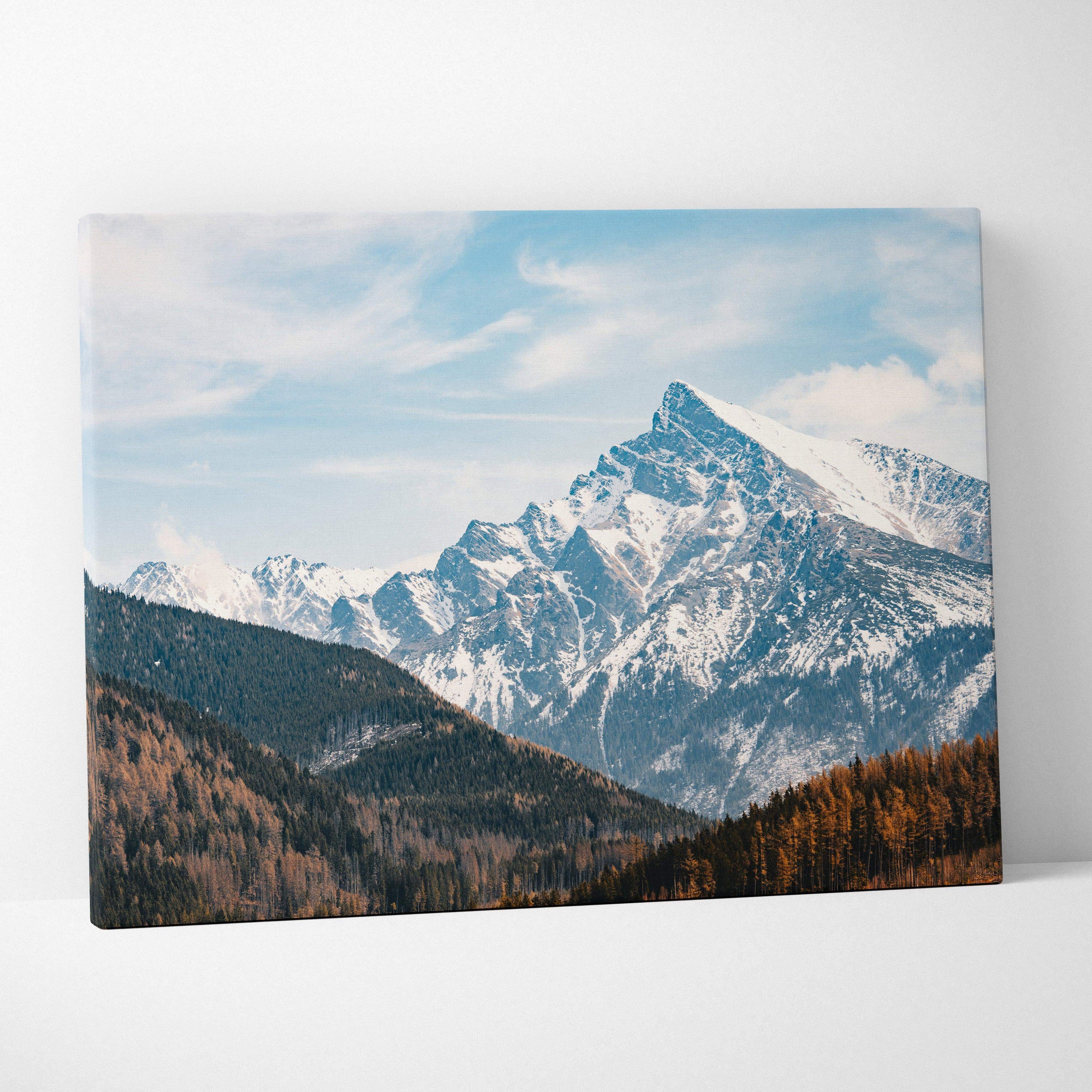 Canvas wall art featuring a snowy mountain landscape with blue sky and pine forest decor.