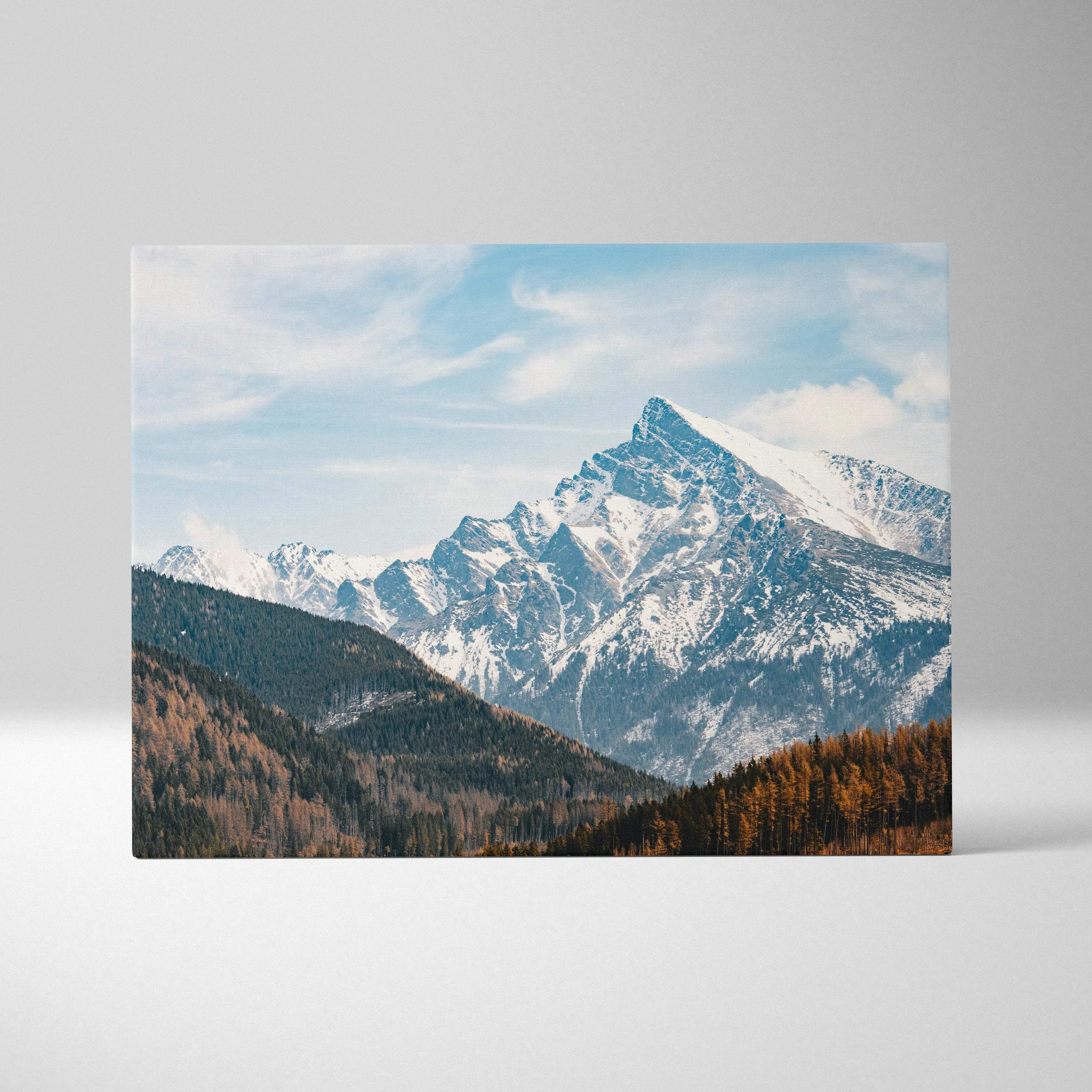 Canvas wall art featuring a digital landscape of snowy mountain peaks under a partly cloudy blue sky.