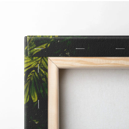 Close-up of wooden frame corner and wrapped canvas edge with green leafy forest wall art decor.