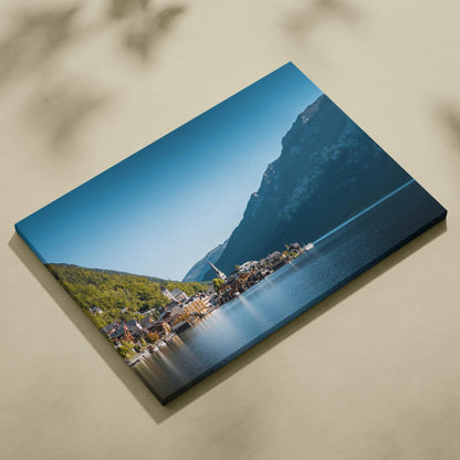 Canvas wall art featuring a serene lakeside village with colorful buildings and mountains under a clear blue sky.