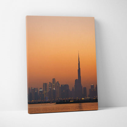 Canvas wall art featuring Dubai's skyline at sunset with warm orange sky and silhouetted skyscrapers including Burj Khalifa.