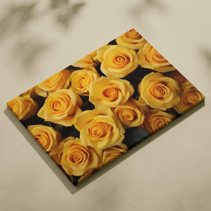 Canvas wall art featuring a close-up of vibrant yellow roses with detailed petals on a dark background.
