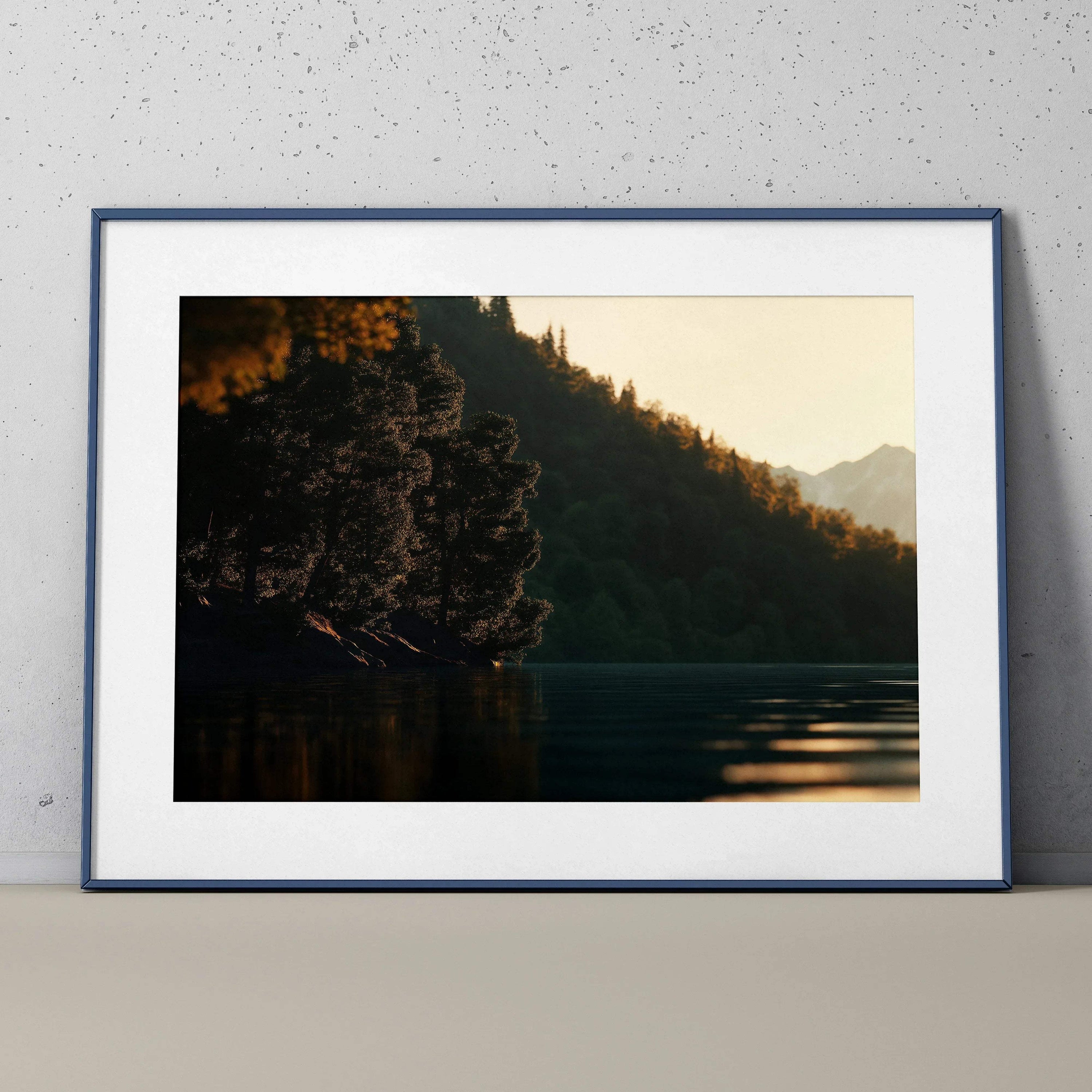 Framed wall art poster featuring a serene sunset over a lake with silhouetted trees and mountains.