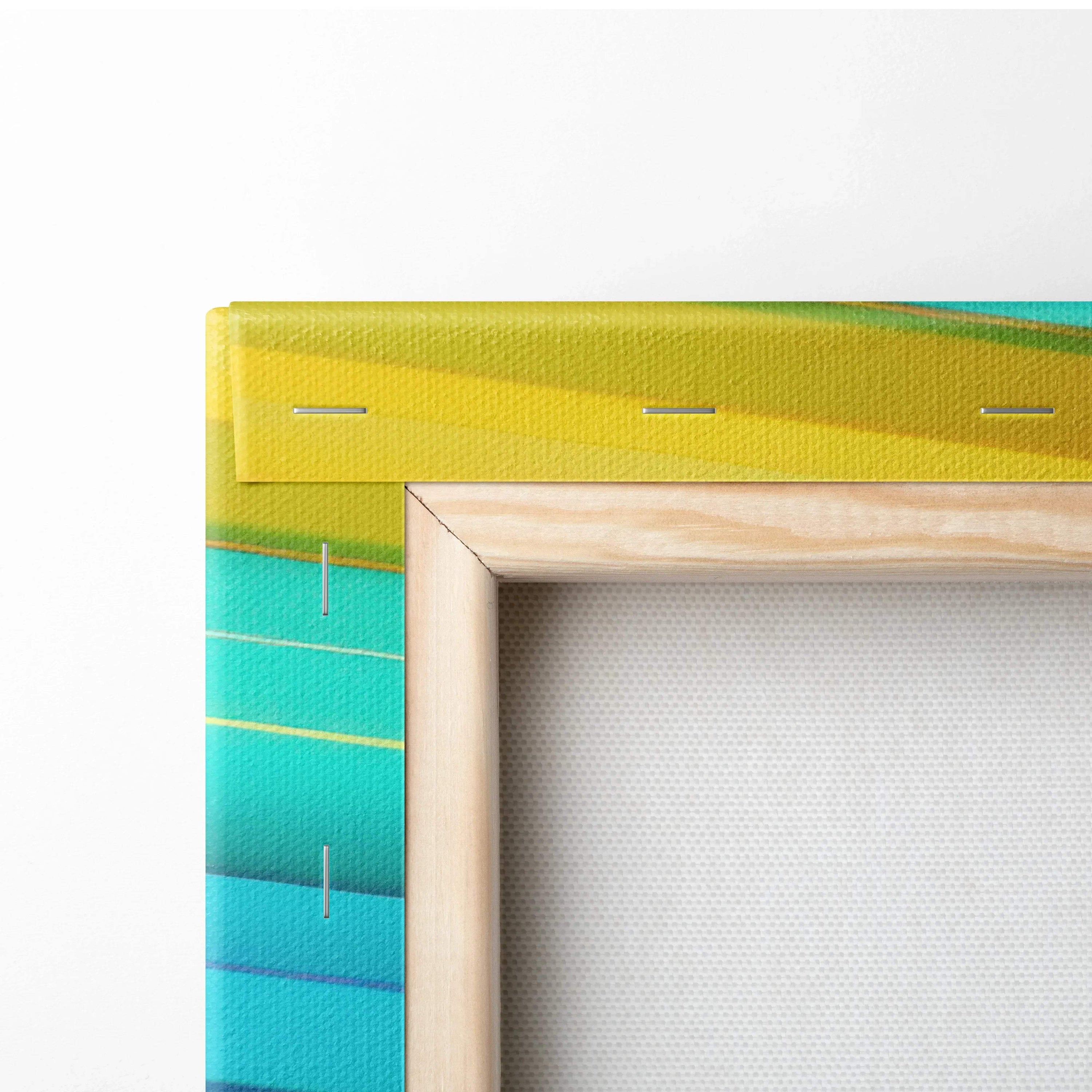 Close-up of canvas edge with vibrant yellow, green, and blue abstract digital print wrapped around thick wooden frame.
