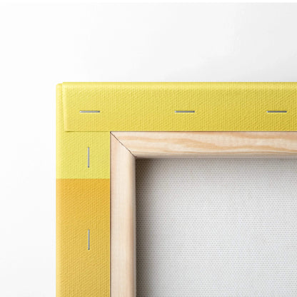 Corner view of a stretched yellow fabric canvas with wooden frame and metal staples securing the fabric.