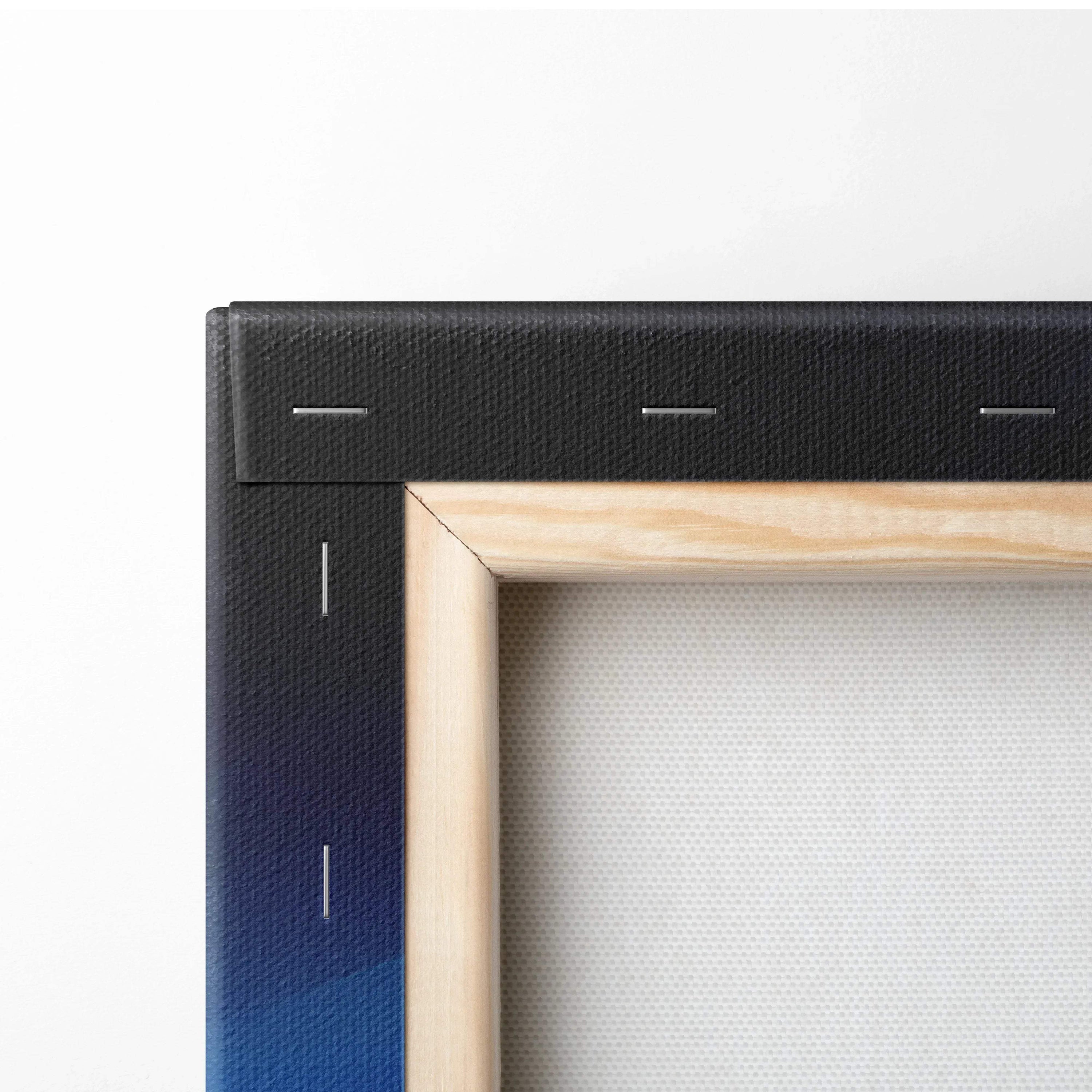 Close-up of canvas art corner with black stapled border and natural wood stretcher frame.