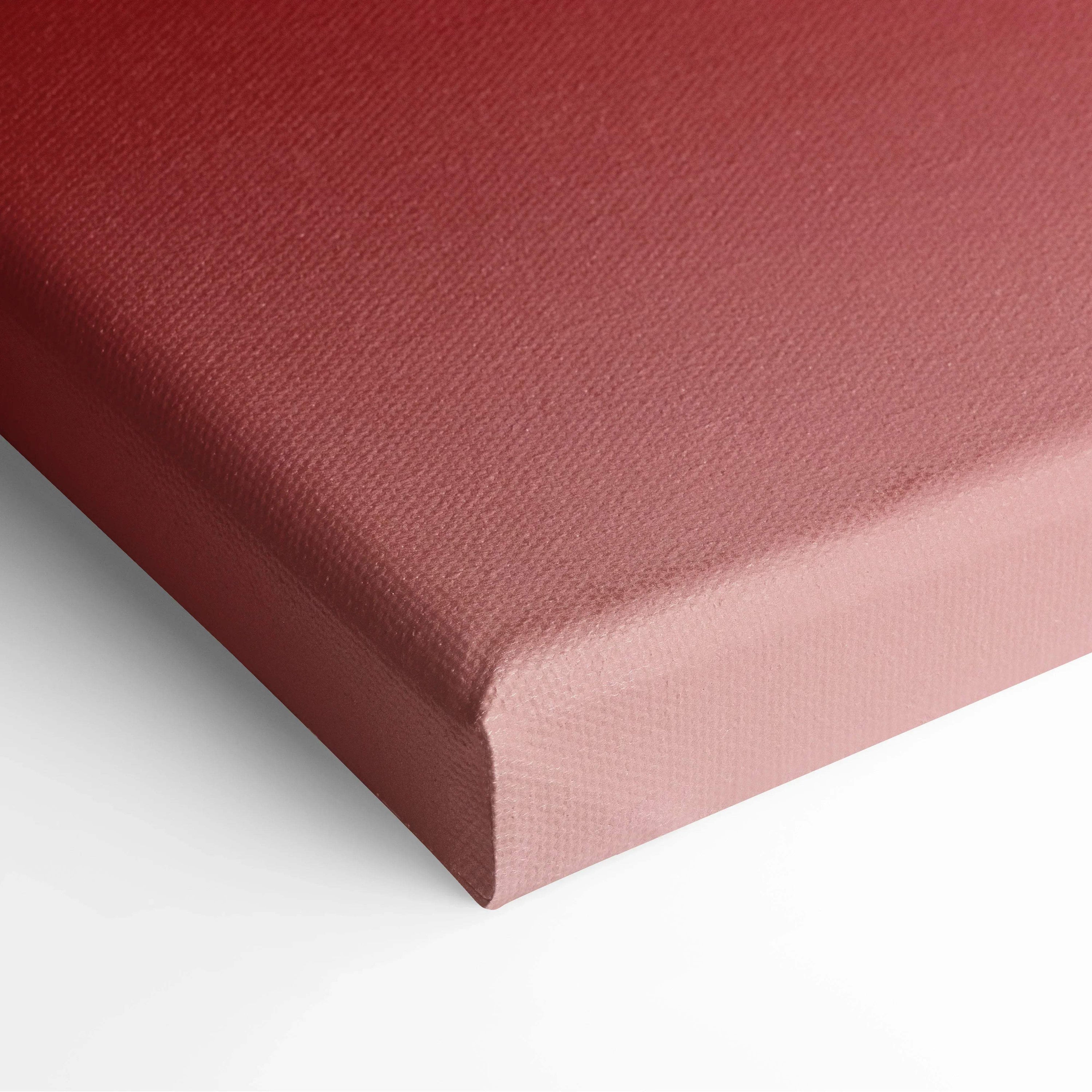Close-up of a textured canvas edge in muted red and pink hues, showcasing thick wrap and fine grain.