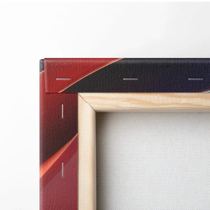 Close-up of stretched canvas art with red and dark blue abstract print wrapped around wooden frame edges.