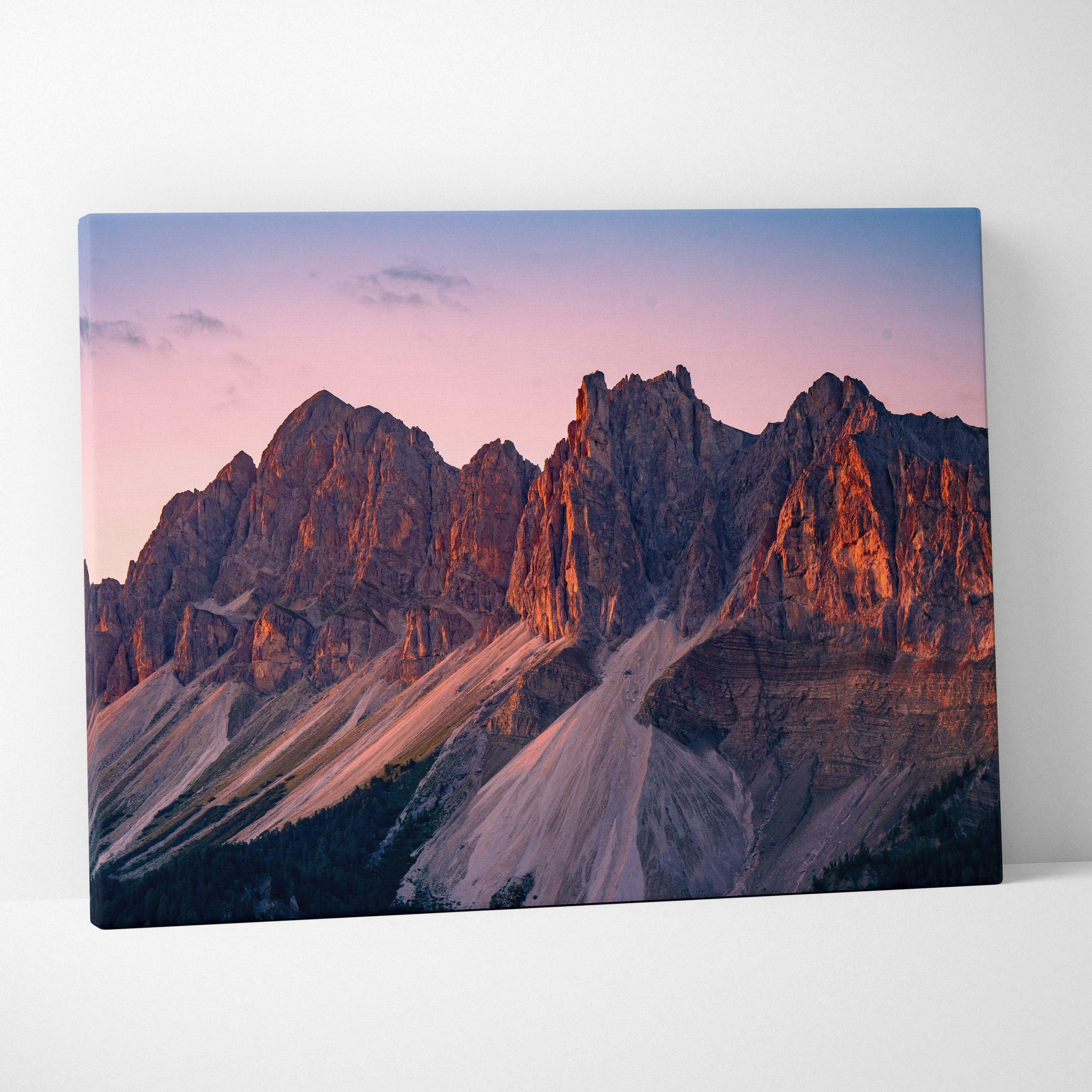 Canvas wall art featuring dramatic mountain peaks illuminated by a vibrant sunset sky.
