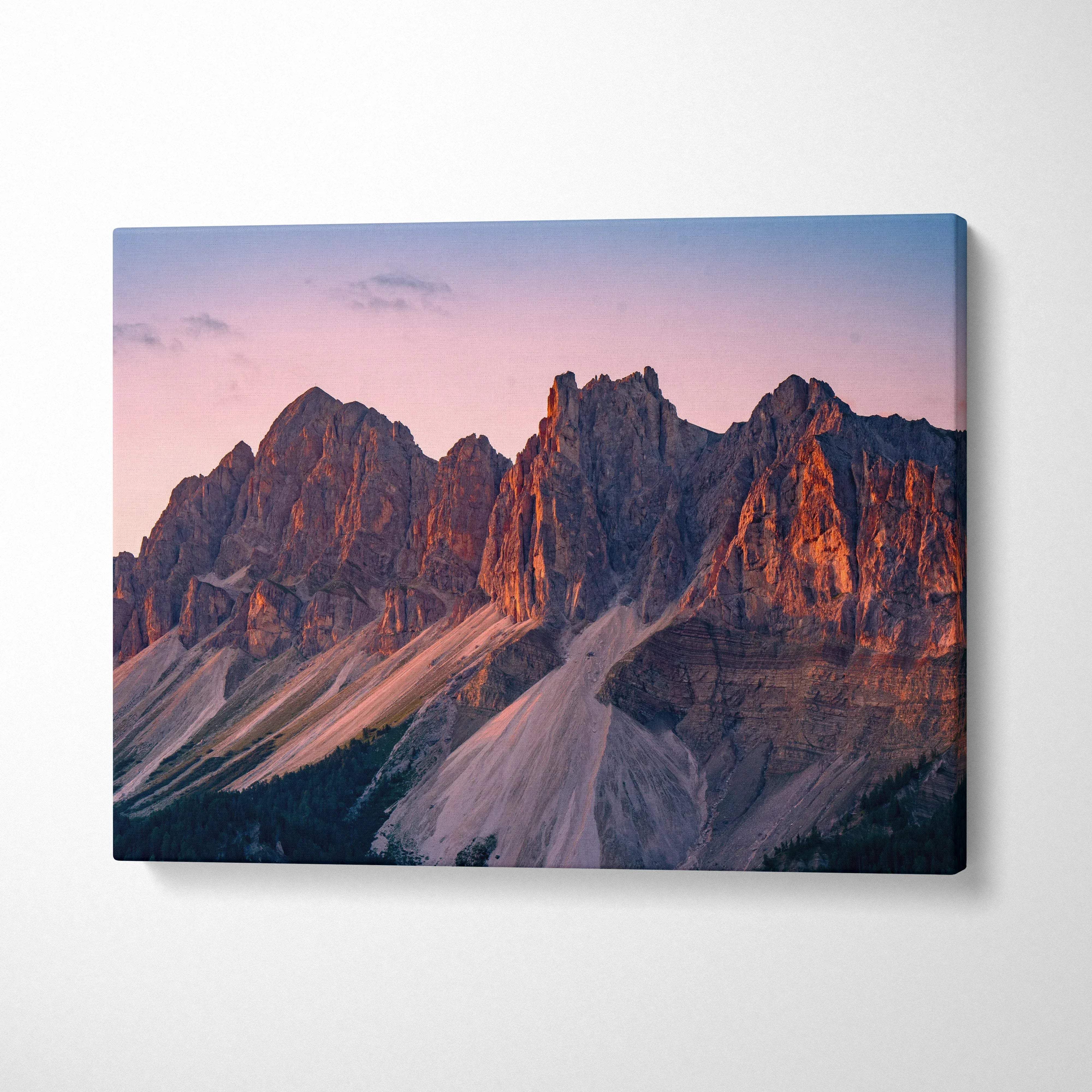 Canvas wall art featuring rugged mountain peaks bathed in warm pink and orange sunset light.