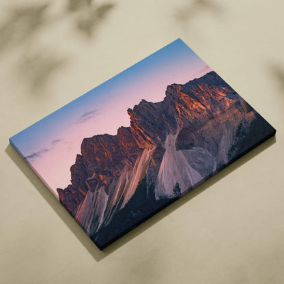 Canvas wall art featuring a colorful sunset casting warm light over rugged mountain peaks.