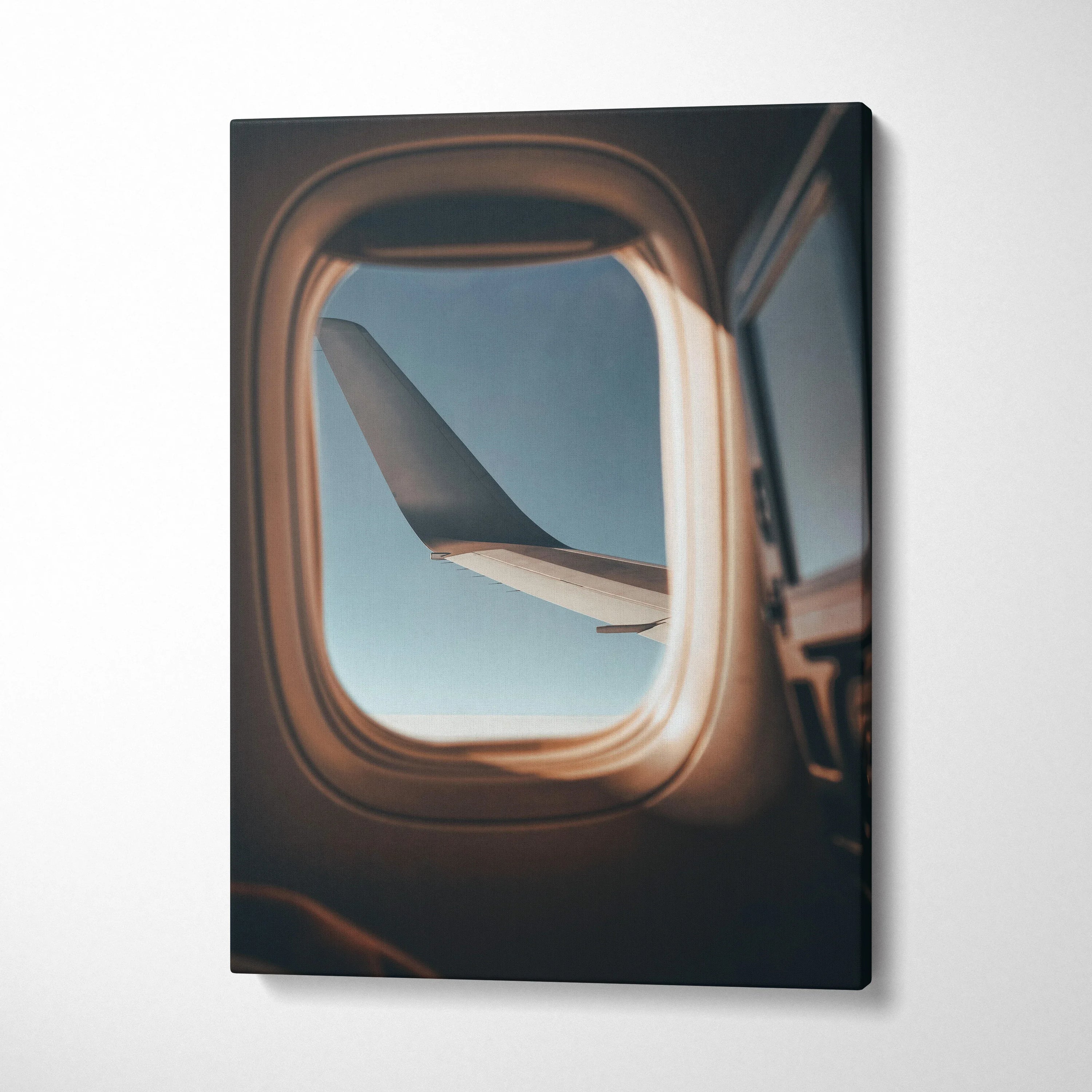 Canvas wall art featuring an airplane wing viewed through an aircraft window with soft natural lighting.