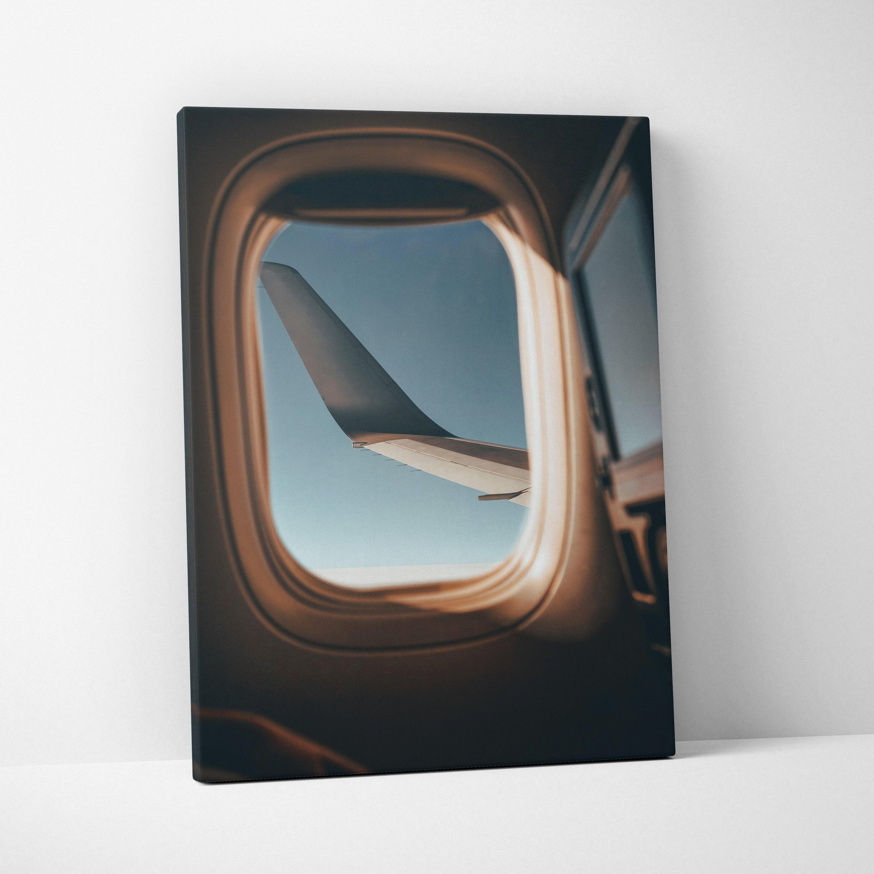Canvas wall art featuring a plane wing viewed through an airplane window with blue sky background.