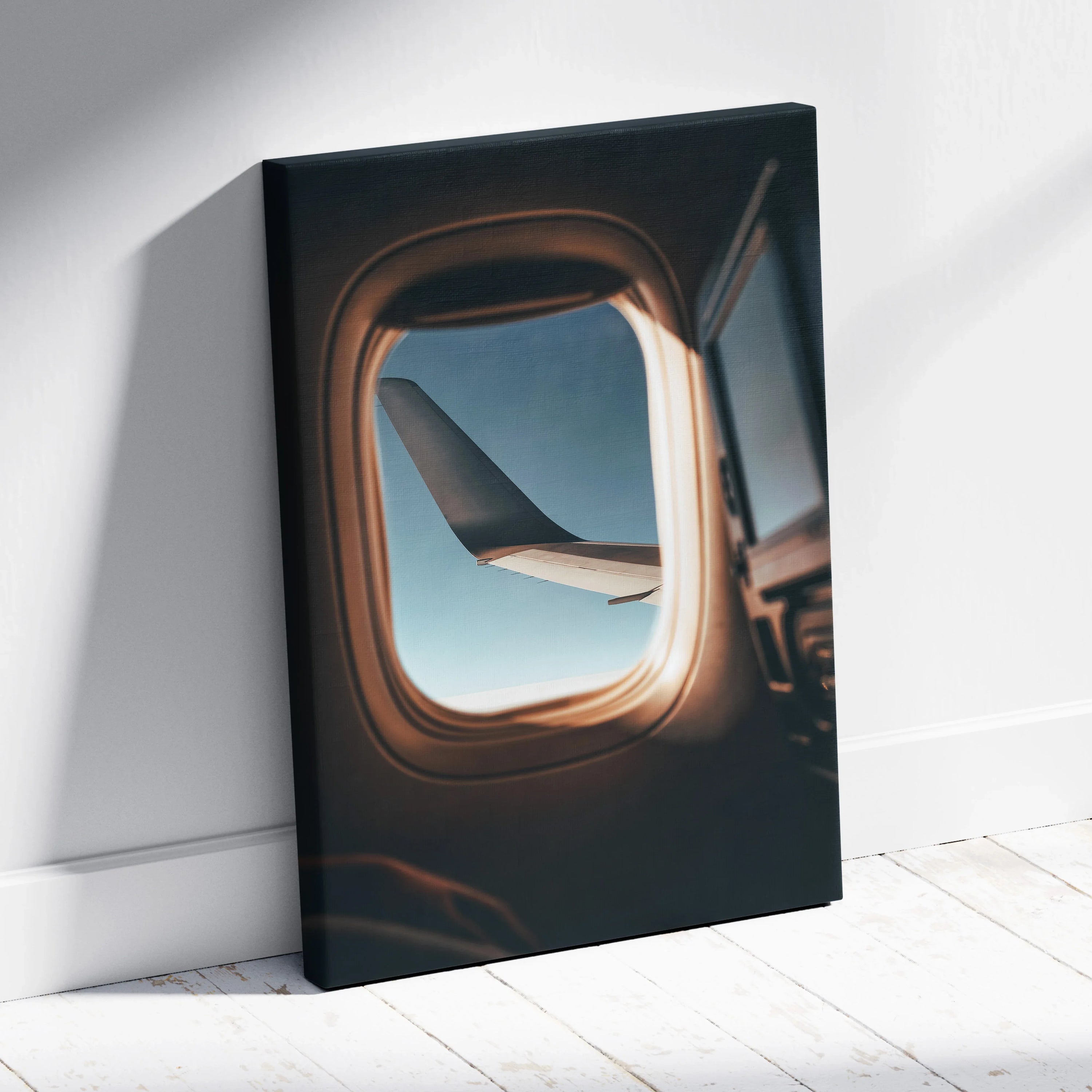 Canvas wall art featuring an airplane wing viewed through a window with soft natural light shadows.
