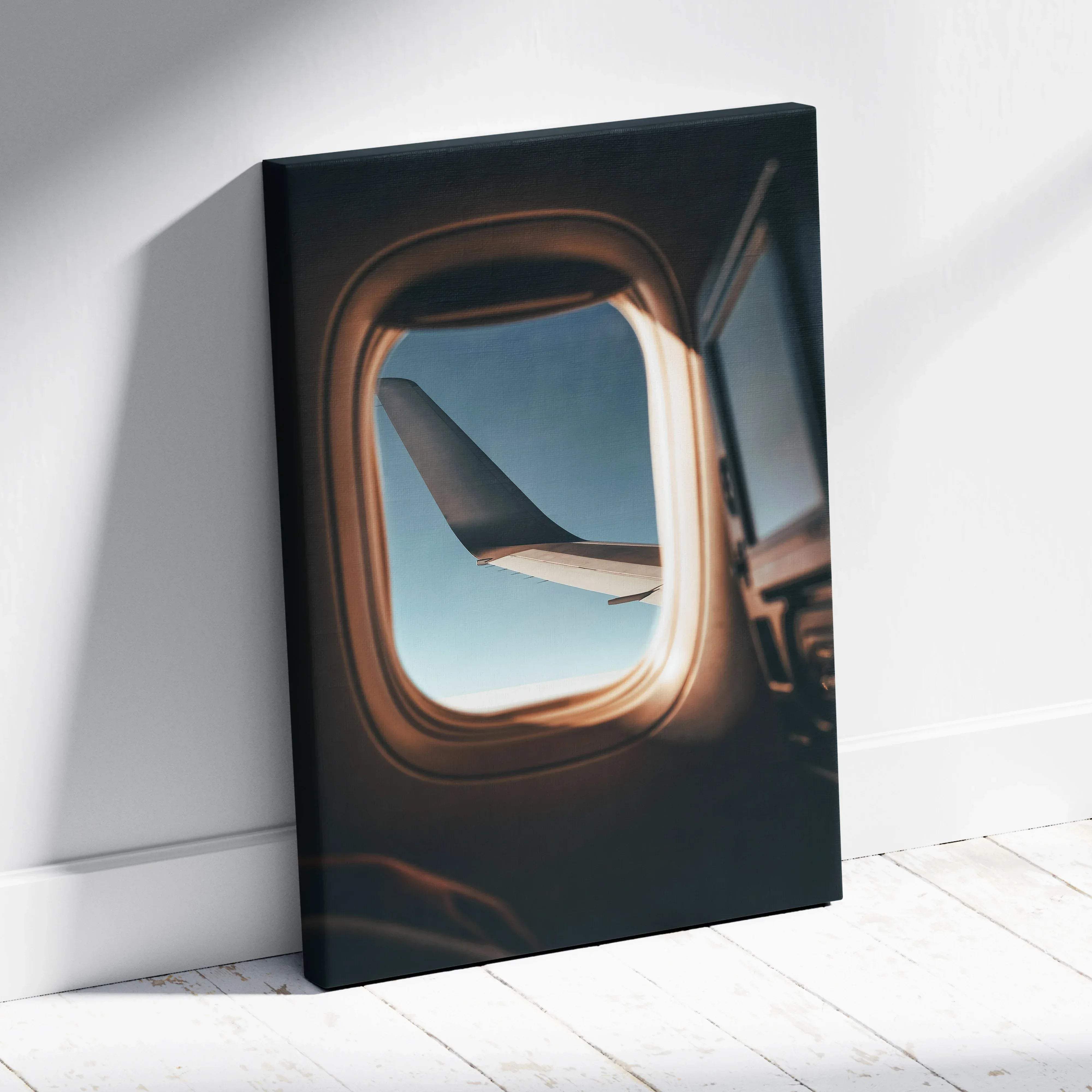 Black canvas print of airplane window view with wing over calm blue sky in soft morning light for wall art