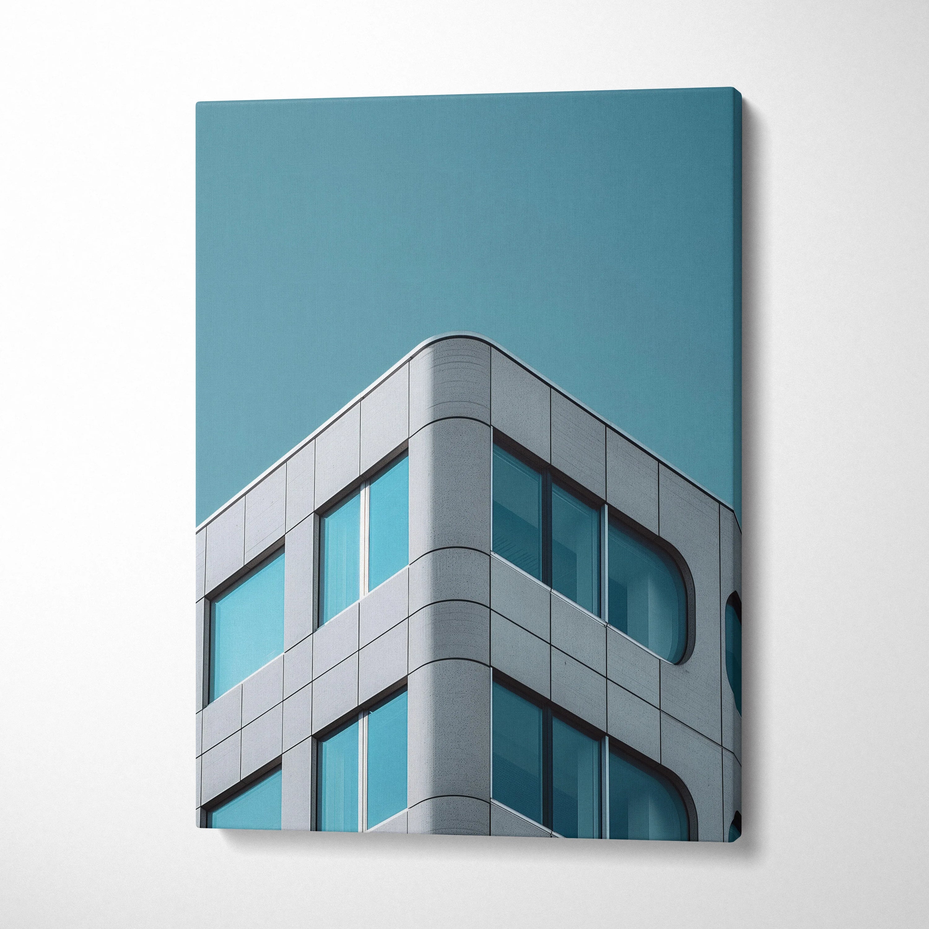 Modern building corner with curved glass windows on blue sky canvas wall art.