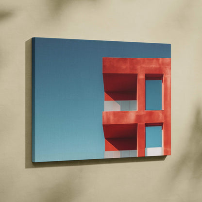 Red modern building detail against blue sky on horizontal canvas wall art print.