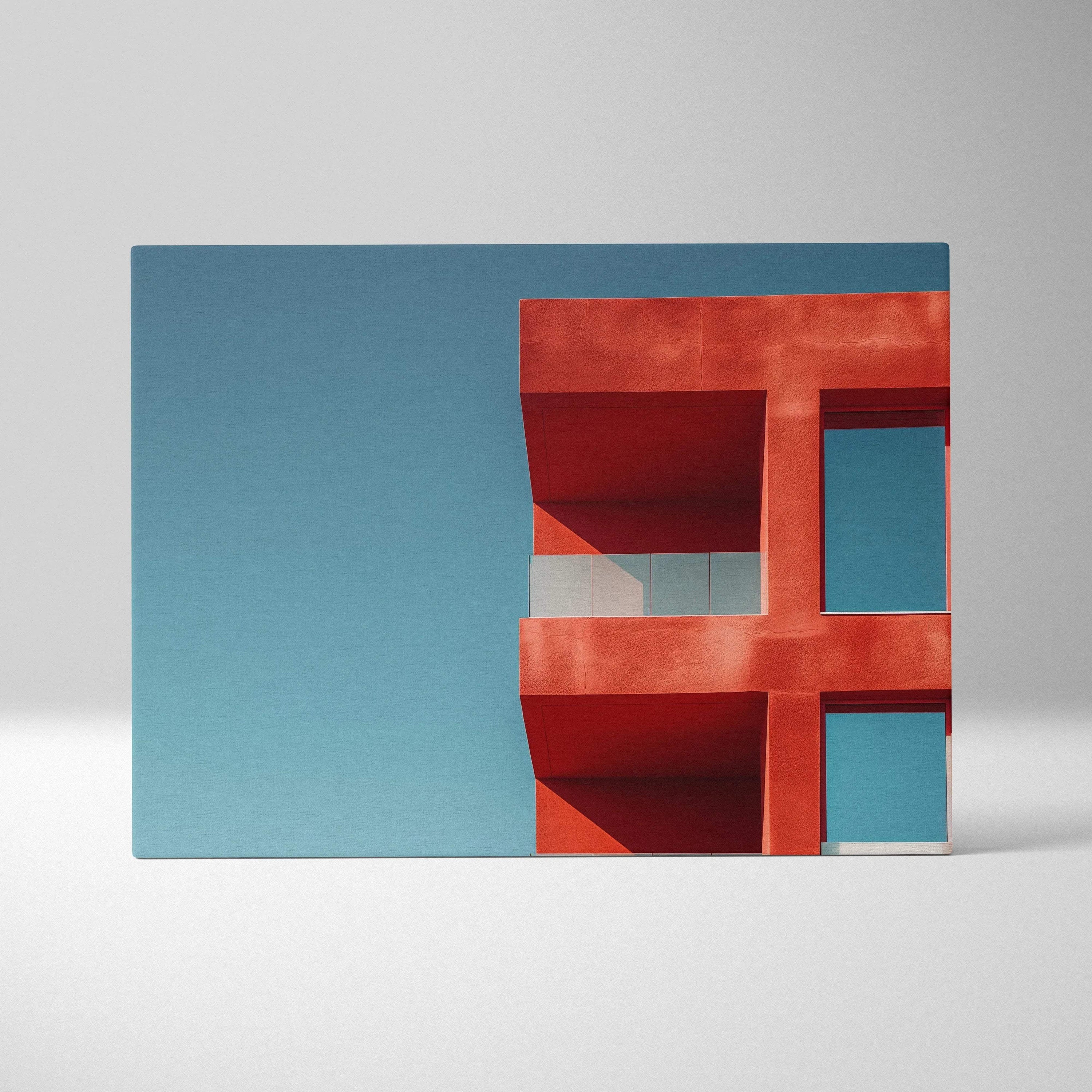 Red modern architectural structure against clear blue sky on rectangular canvas wall art print.
