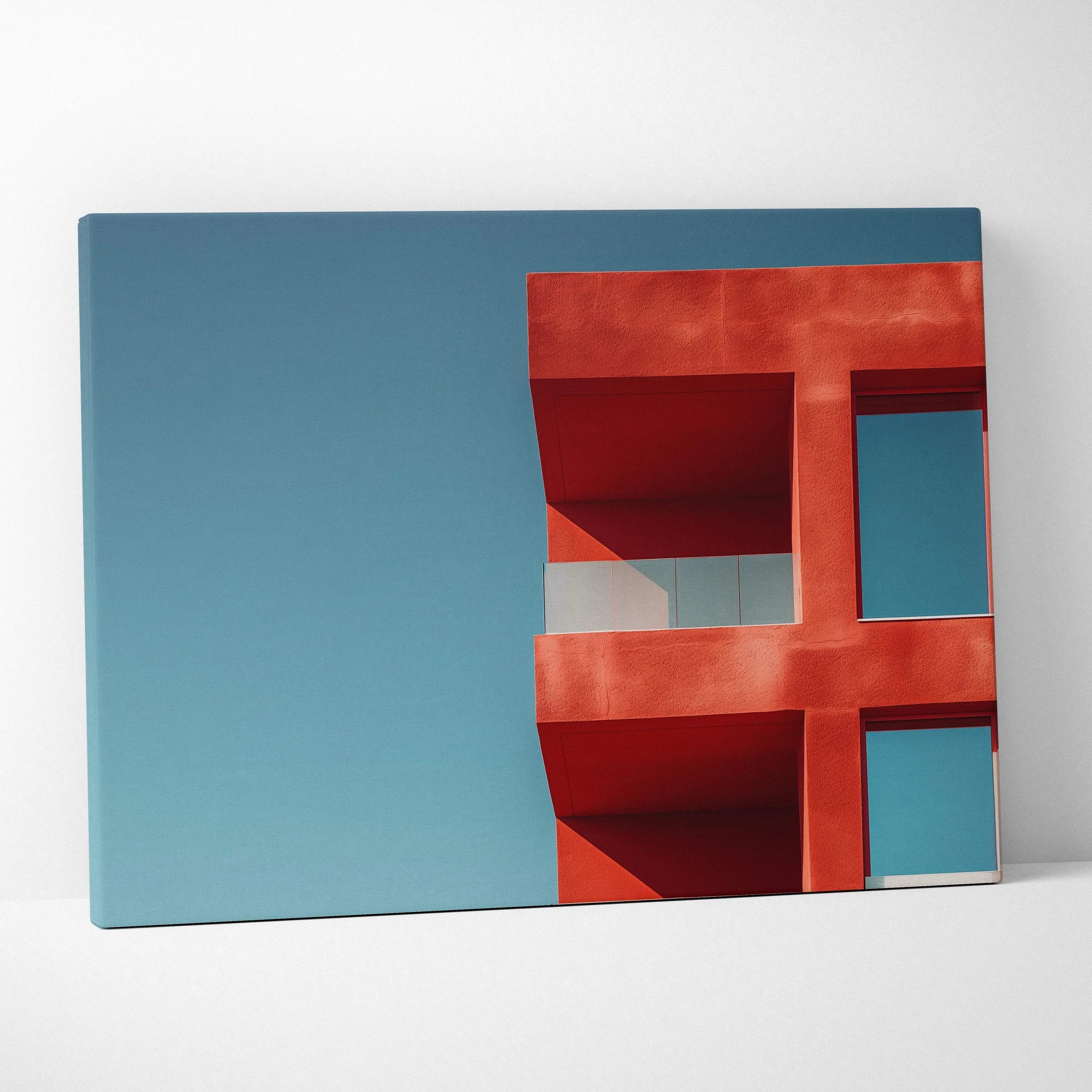 Canvas wall art featuring a red geometric building facade against a clear blue sky.
