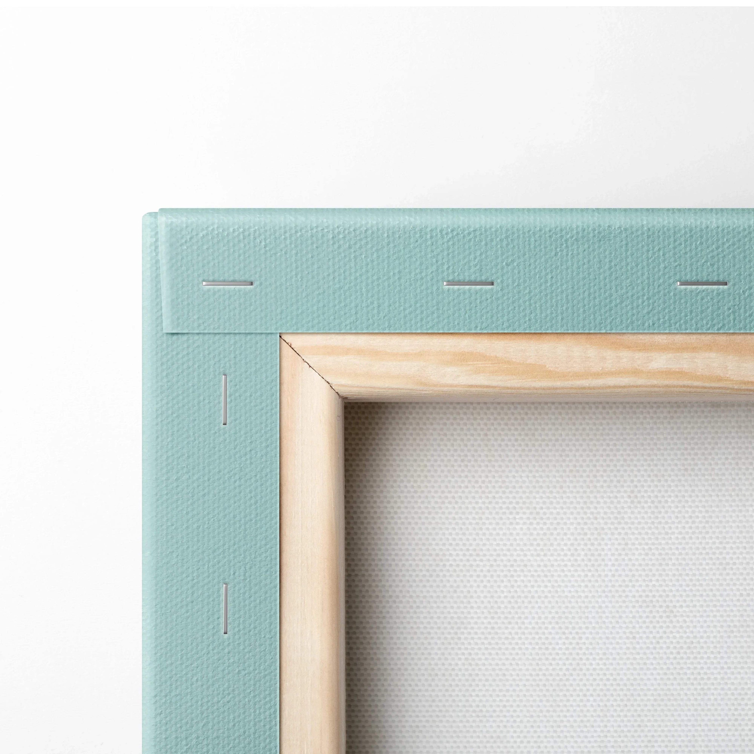 Close-up of stretched canvas art with natural wood frame and light blue fabric edge on back of digital wall art.