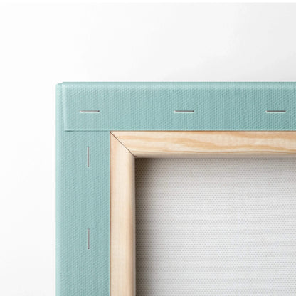 Close-up of stretched canvas art with natural wood frame and light blue fabric edge on back of digital wall art.