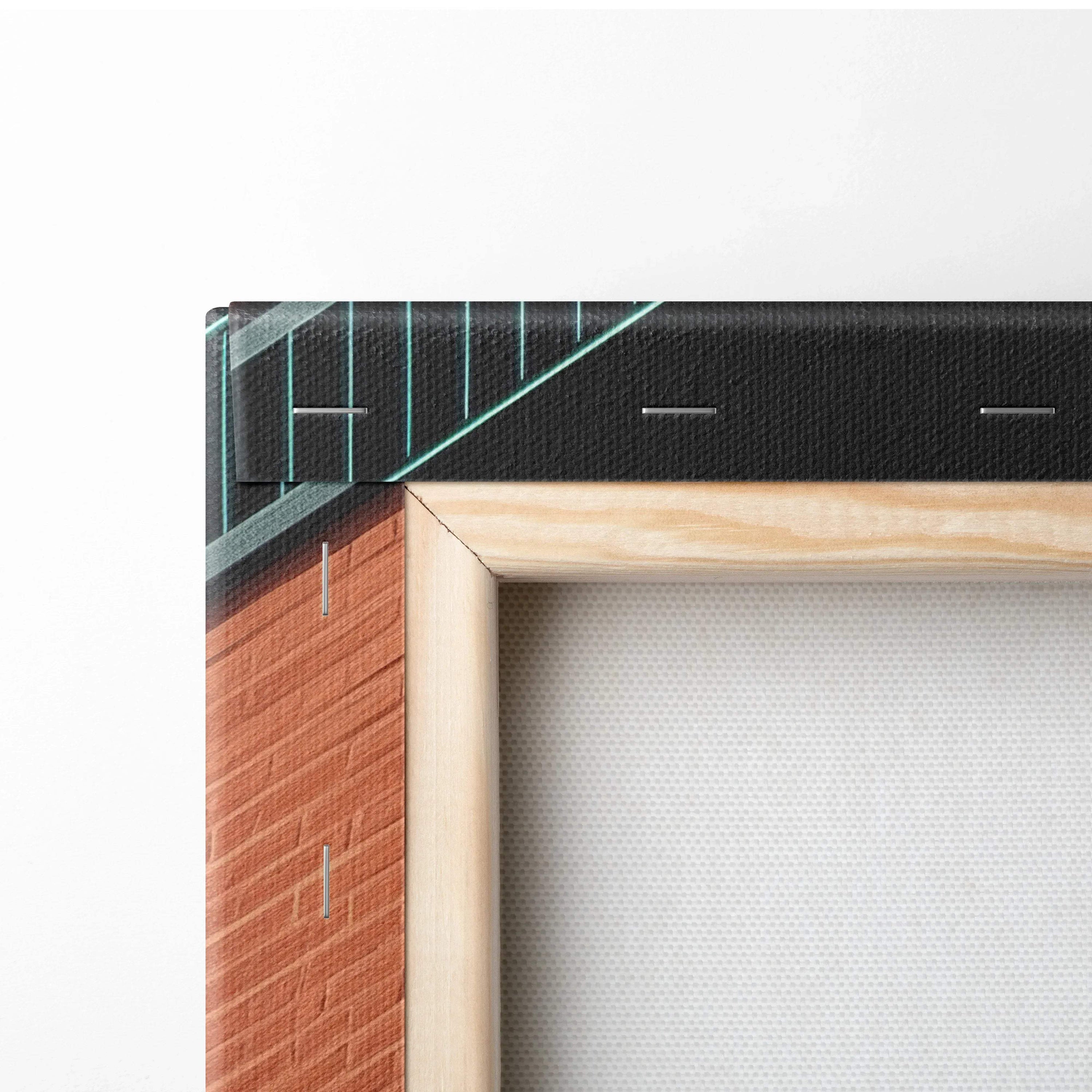 Close-up of wooden frame corner with wrapped digital art canvas featuring black and teal geometric building design.