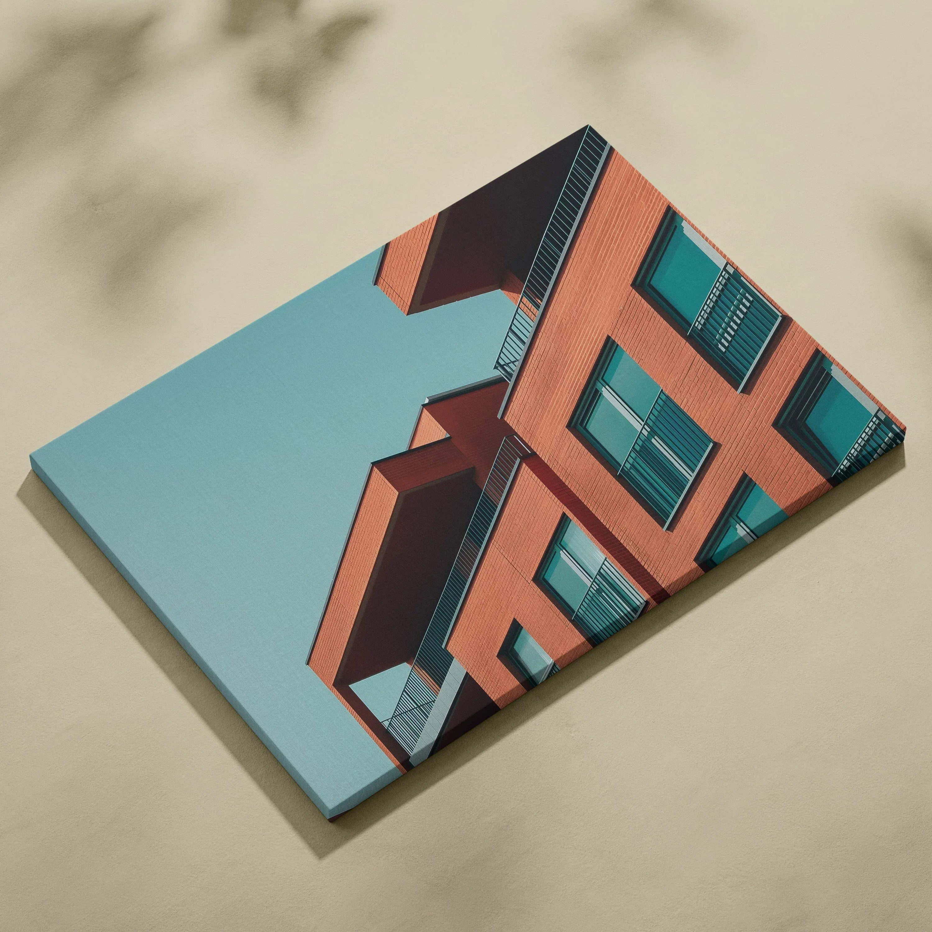 Modern geometric building design printed on canvas wall art with blue sky background.