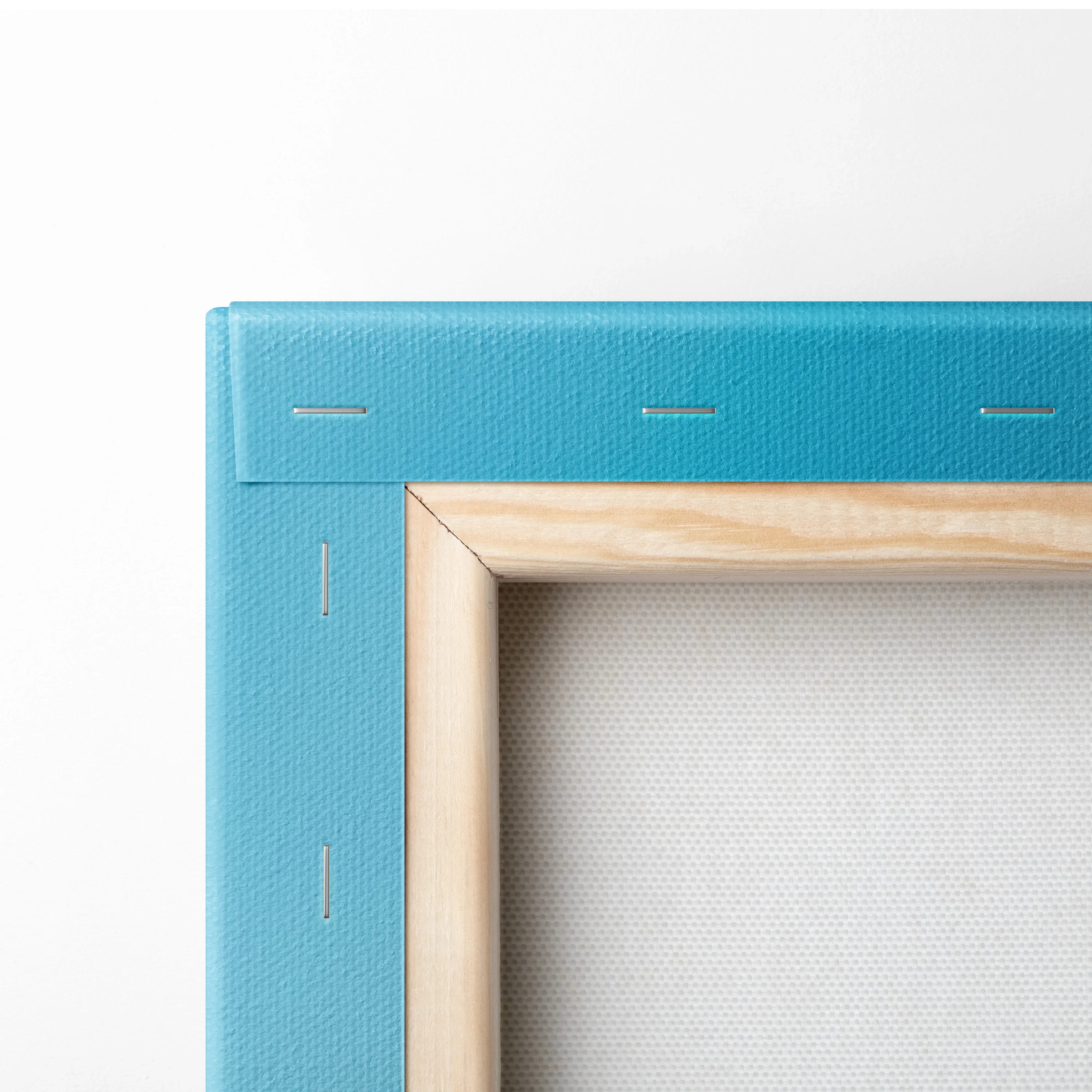 Close-up of blue canvas wall art corner with natural wood frame and stitched edges.
