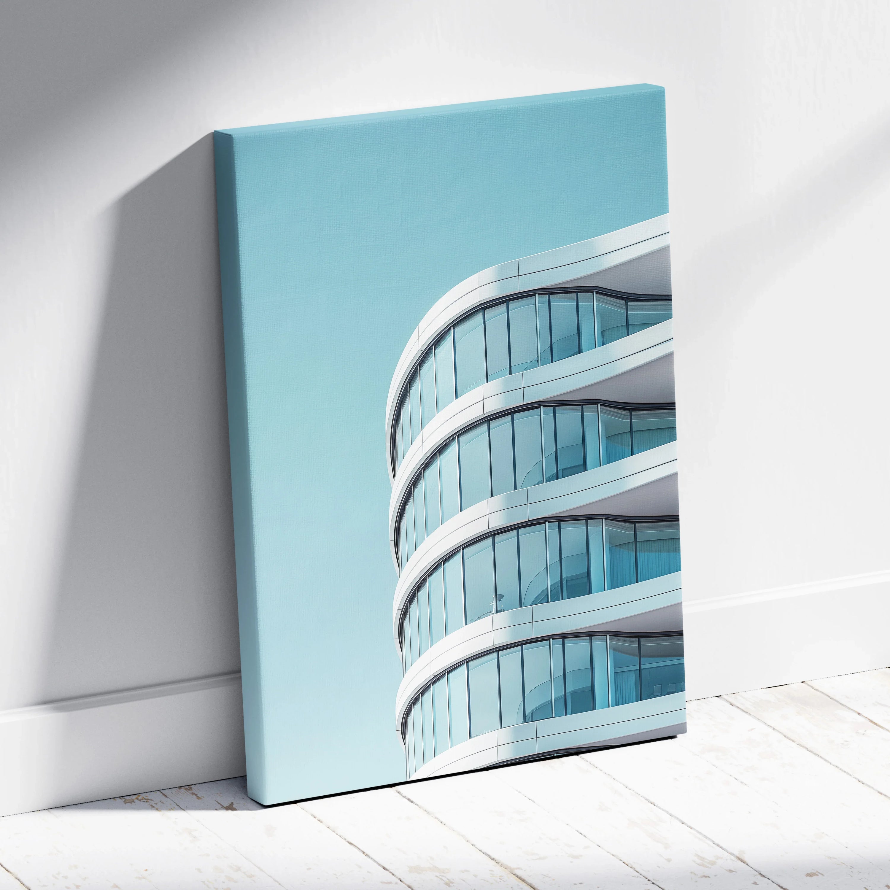 Modern curved glass building architectural canvas wall art with blue sky background.