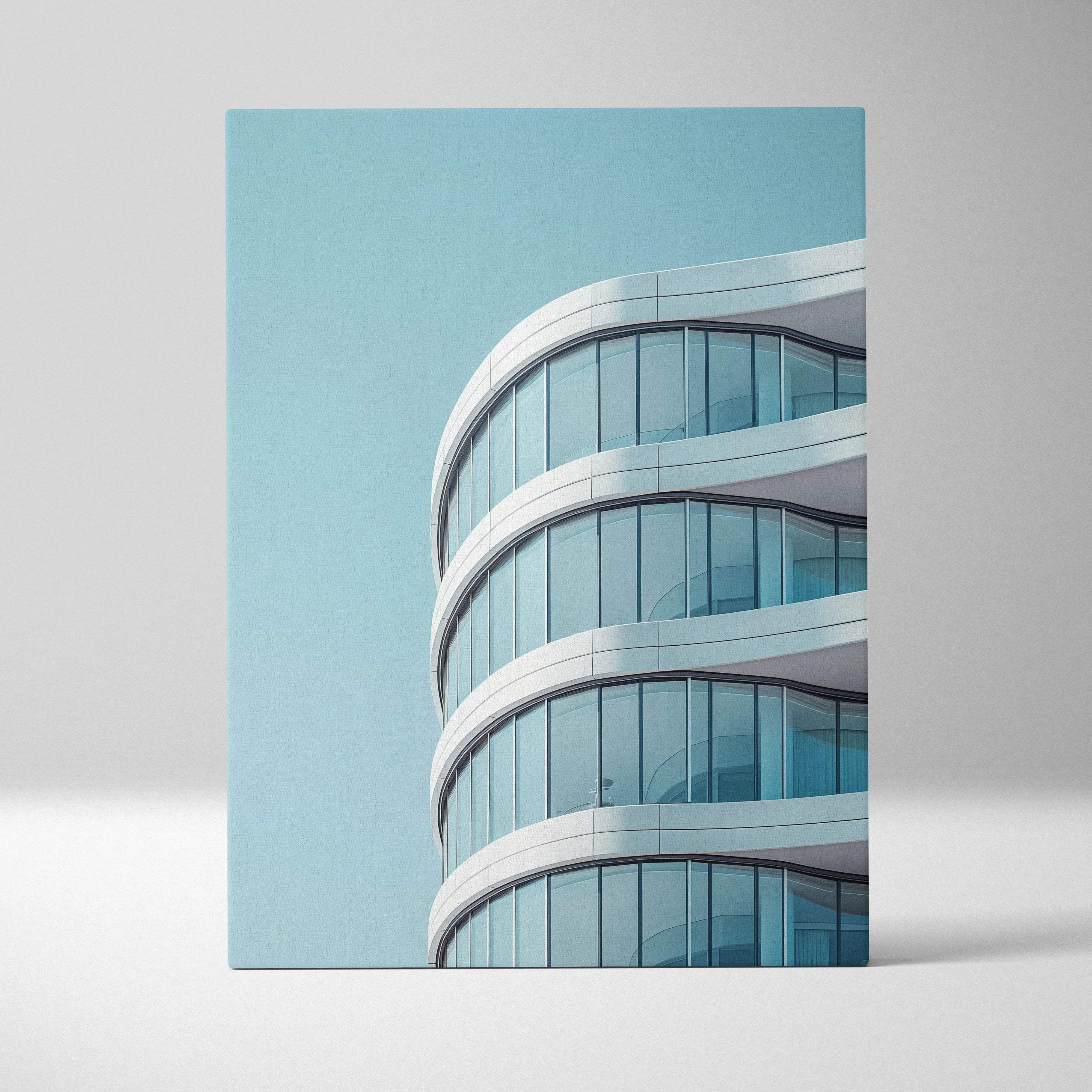 Contemporary architecture canvas wall art featuring a modern curved glass building with white accents and blue sky