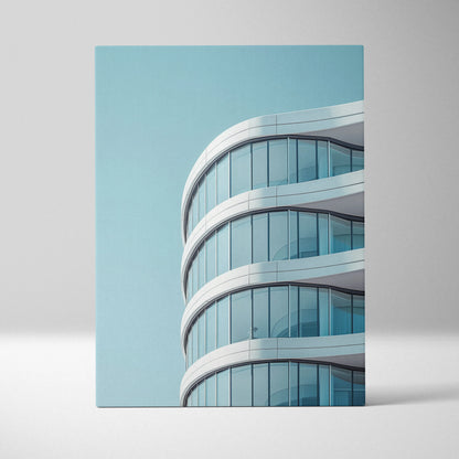 Modern curved architectural building depicted on vertical canvas wall art with smooth white accents and blue sky background.