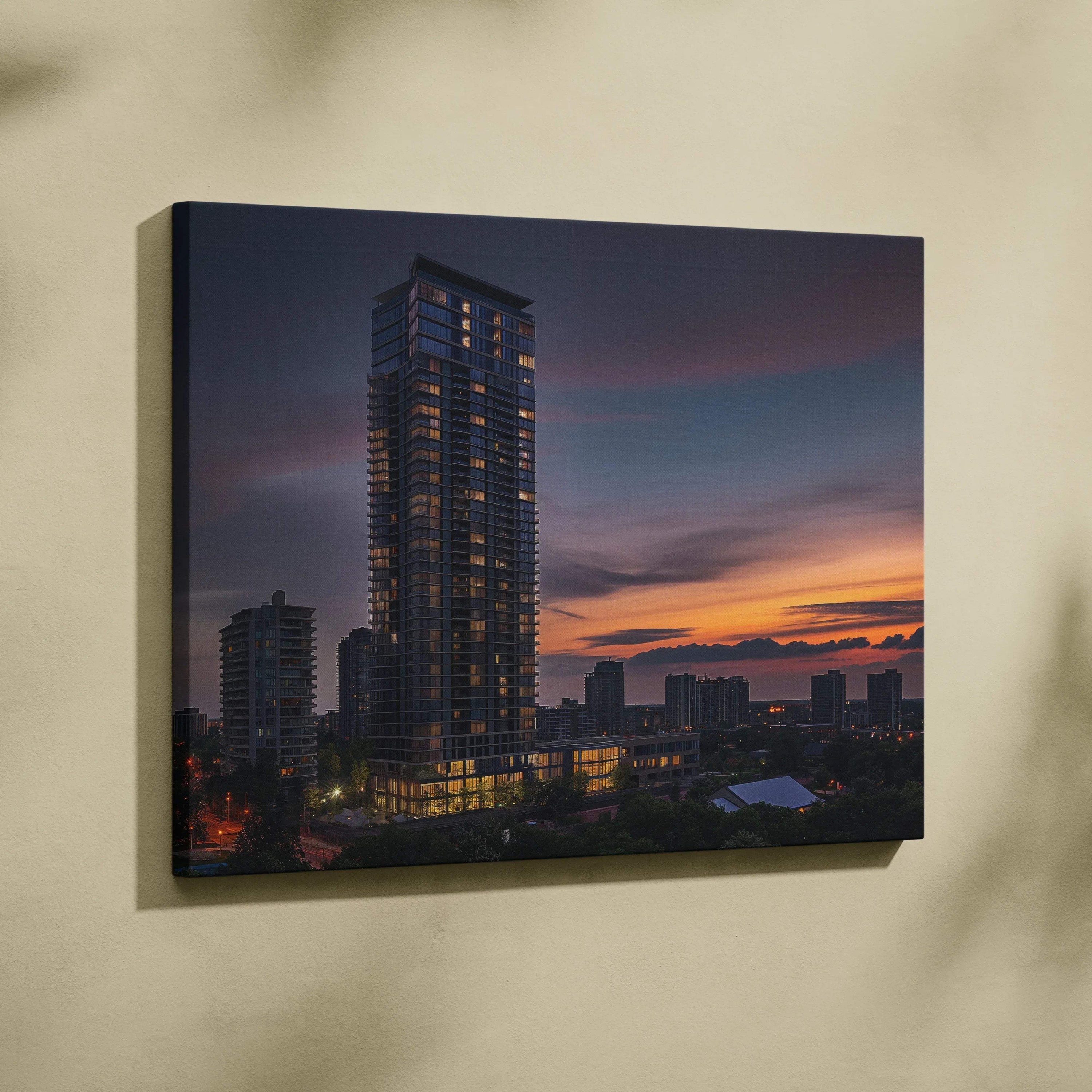 Canvas wall art featuring a tall modern building at sunset with cityscape silhouette.