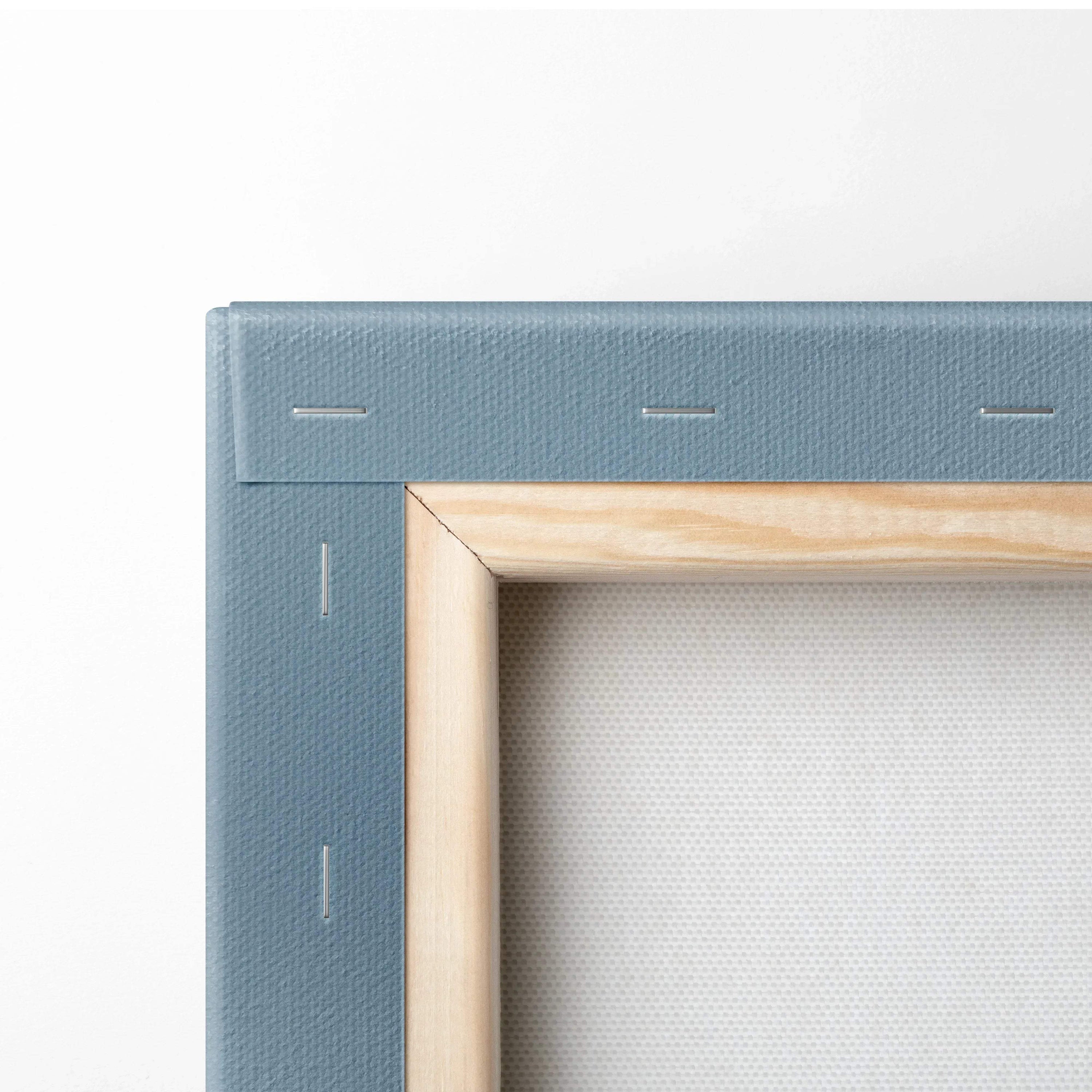 Close-up of stretched white canvas fabric over wooden frame with blue backing for wall art display.
