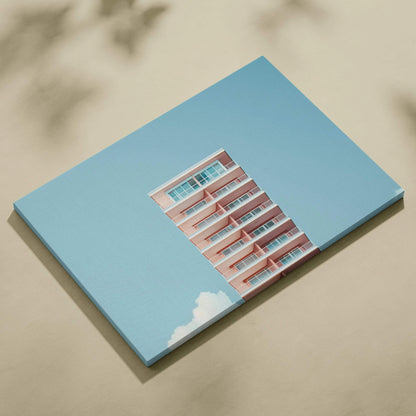 Canvas wall art featuring a pink modern building against a clear blue sky with white clouds, digital design.