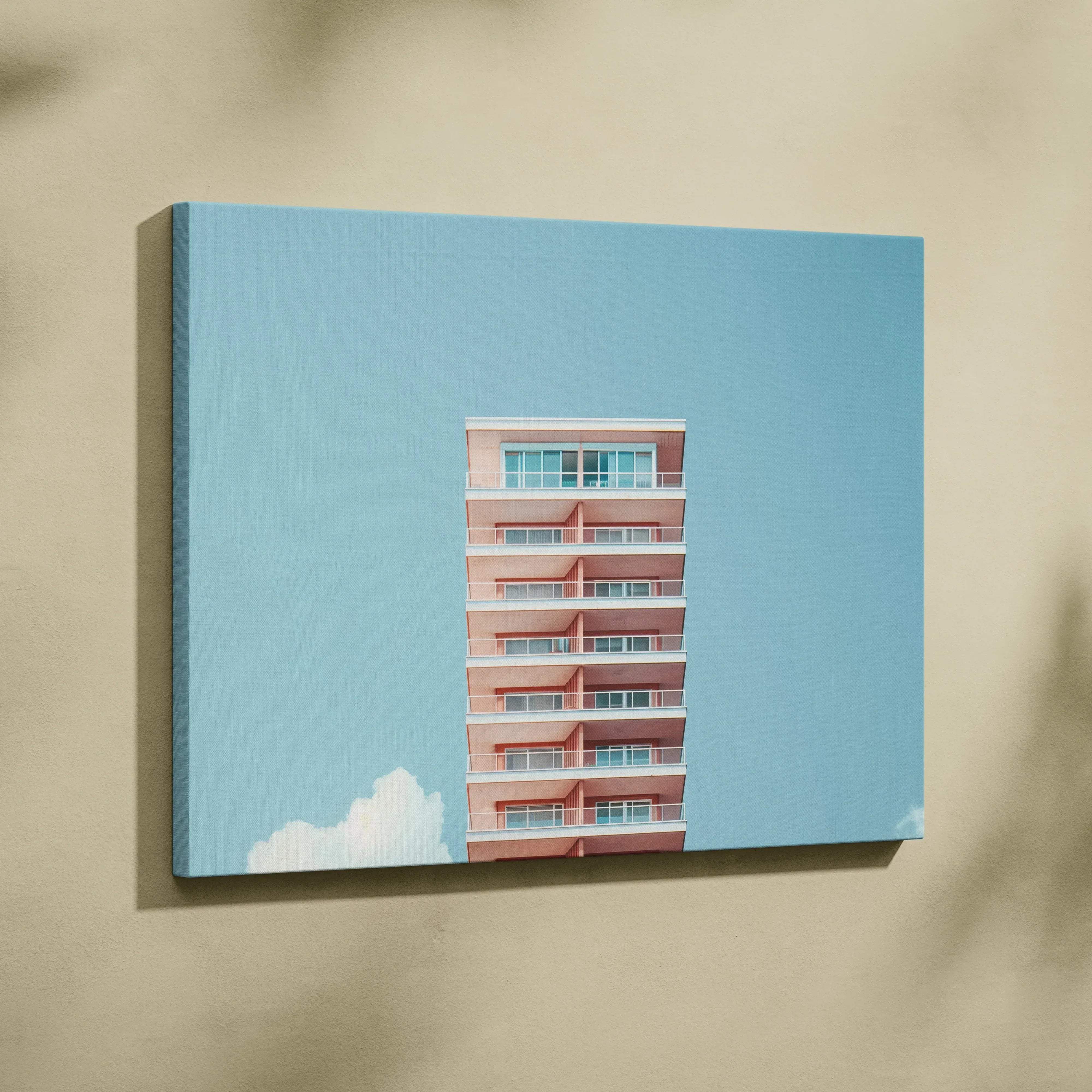 Rectangular canvas wall art featuring a pastel retro multi level pink apartment building with white balconies against sky blue