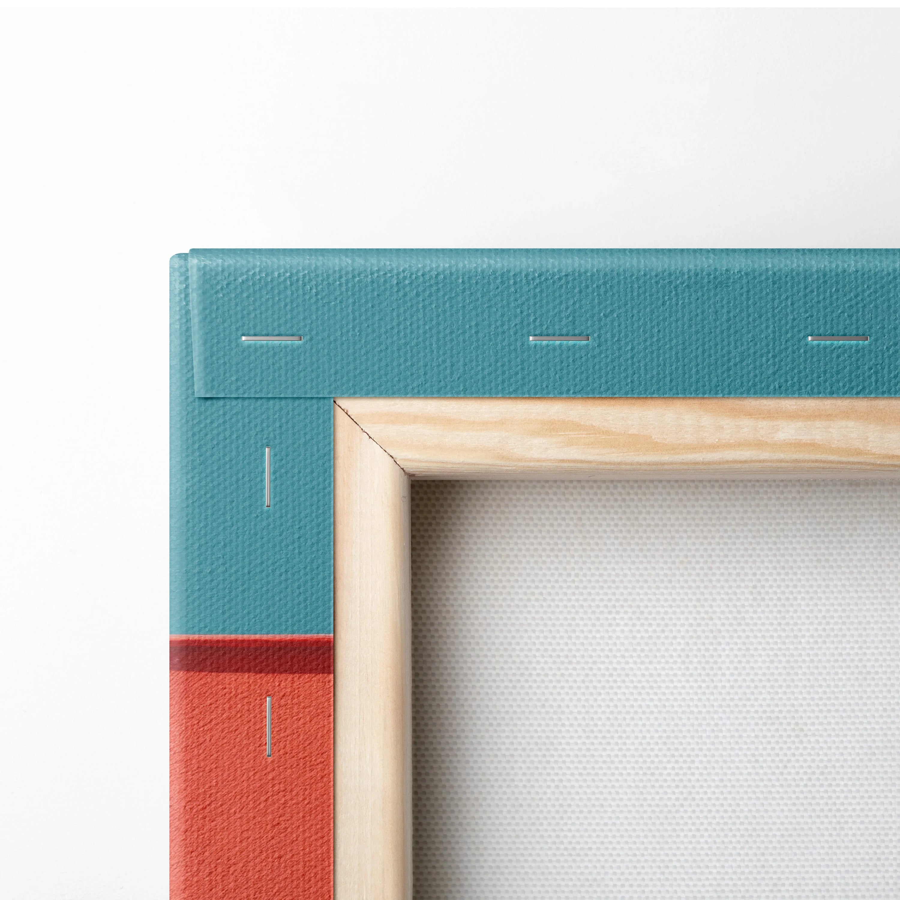 Corner detail of teal and red canvas art stretched on wooden frame for wall art.