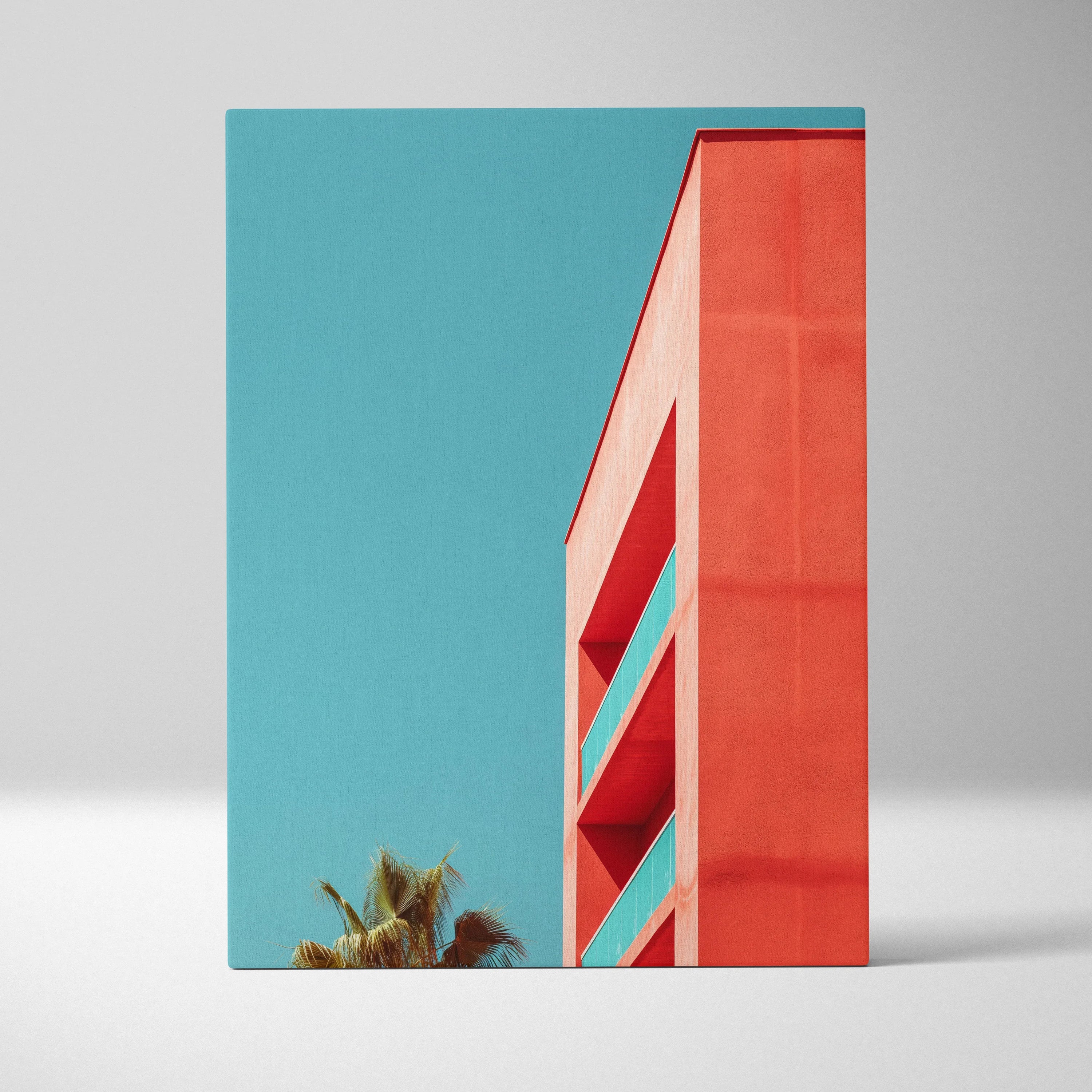 Modern architecture canvas wall art featuring red building corner against clear blue sky with palm tree, vertical canvas art.