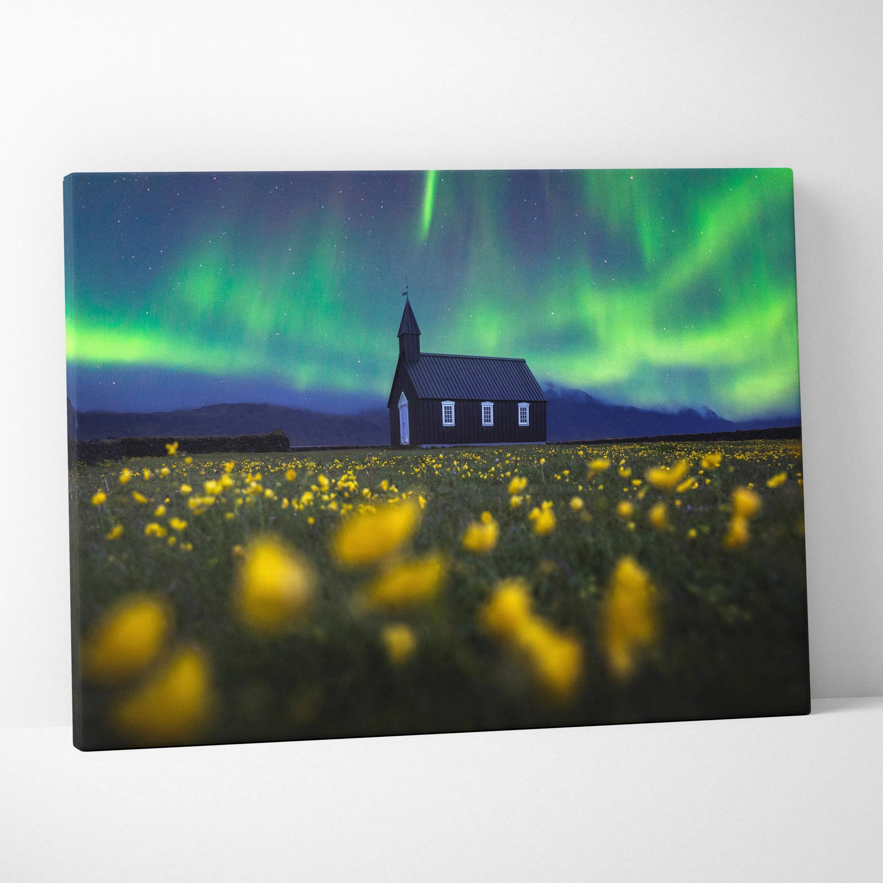 Nocturnal Vision: Aurora Borealis over black wooden church in wildflower field canvas art