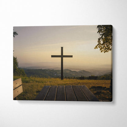 Canvas wall art featuring a wooden cross at sunset over grassy hills and distant mountains.